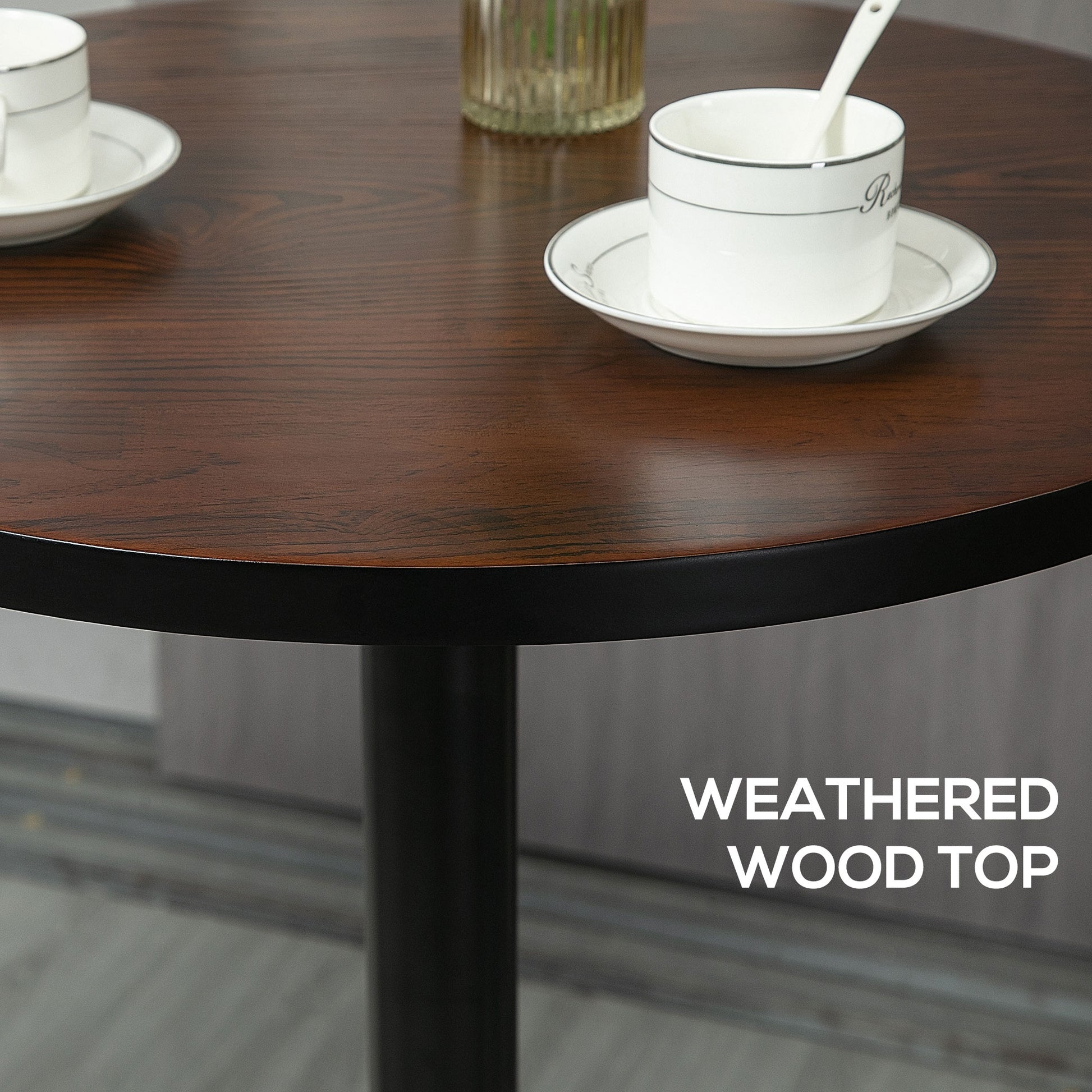 Round dining table with a dark weathered wood top and black pedestal base