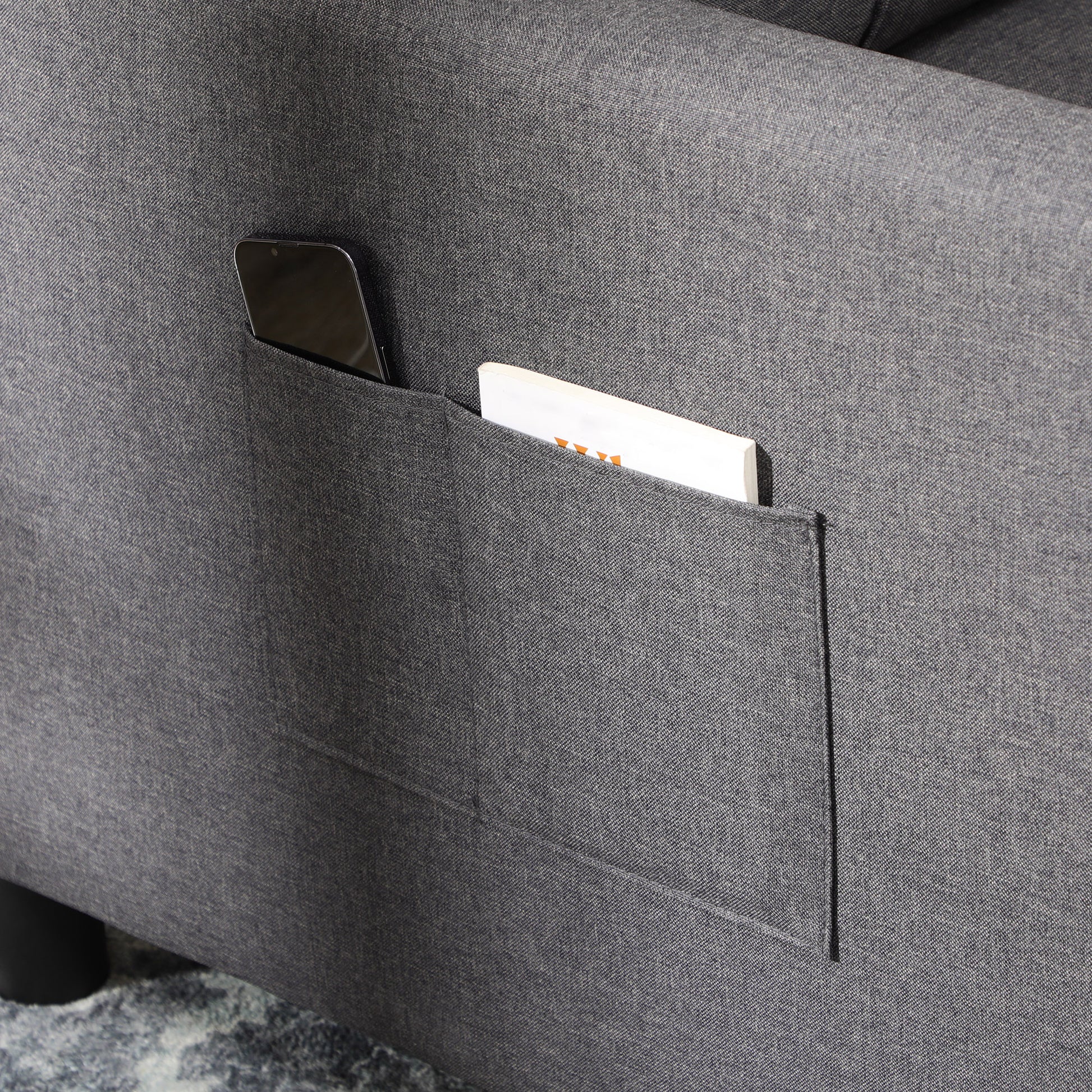 Dark grey fabric sofa with integrated phone and book pocket