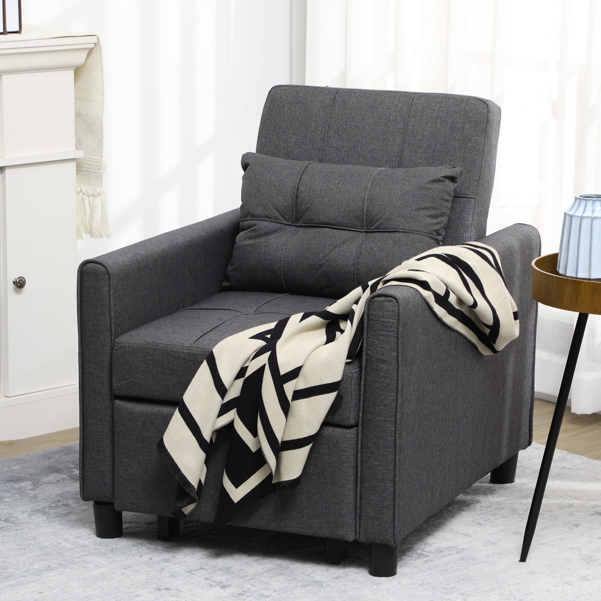 Dark gray upholstered accent chair with tufted back and matching throw pillow