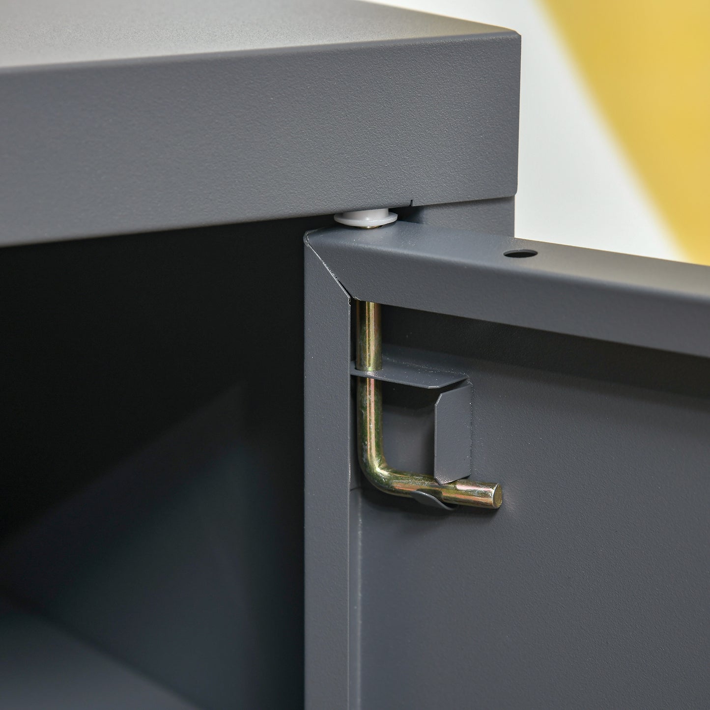 Closeup of a grey metal cabinet hinge mechanism for a filing cabinet