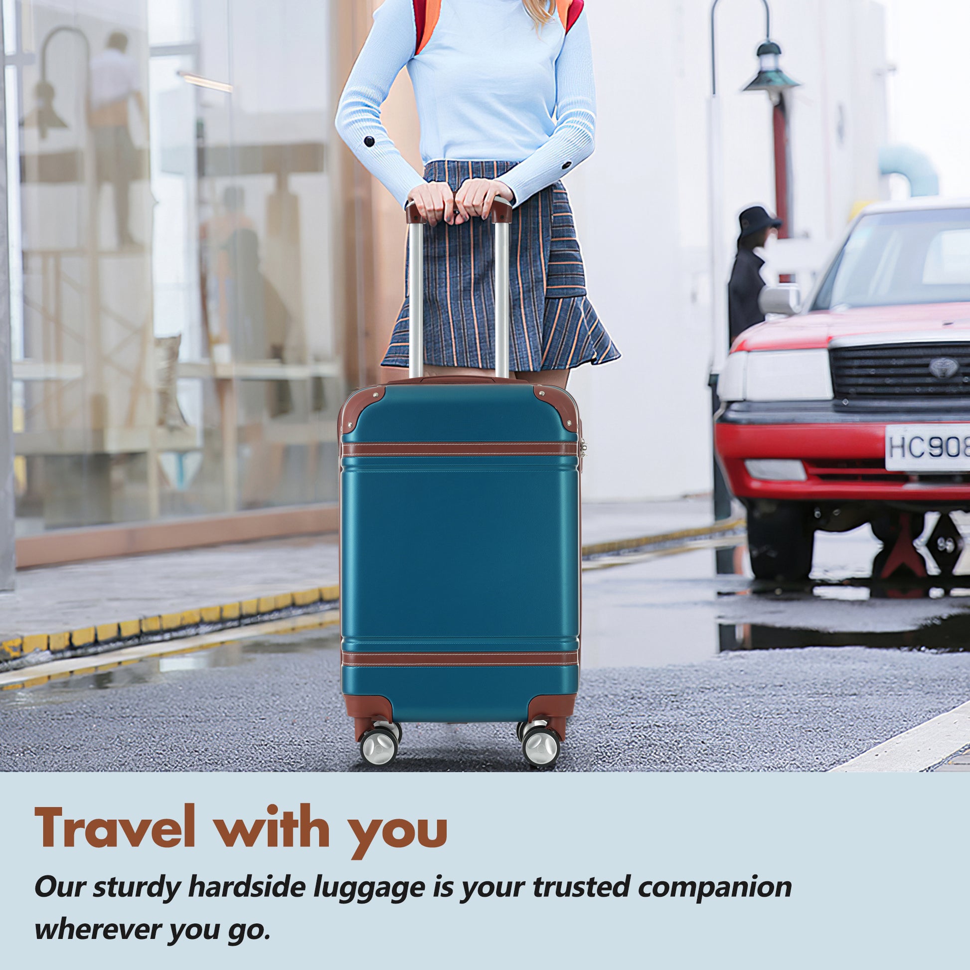Teal hardside luggage with brown trim and silver wheels held by a person outdoors