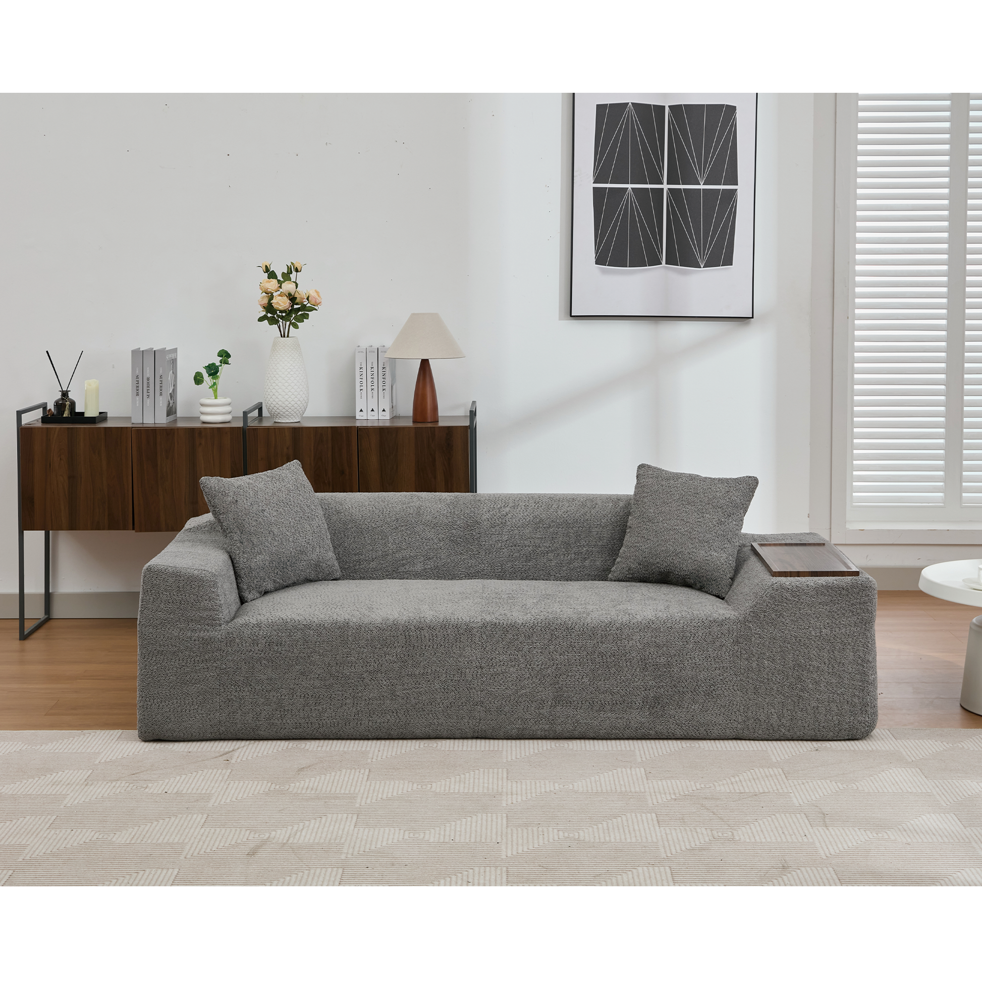 Contemporary grey boucle fabric sofa with two scatter cushions and attached side tray