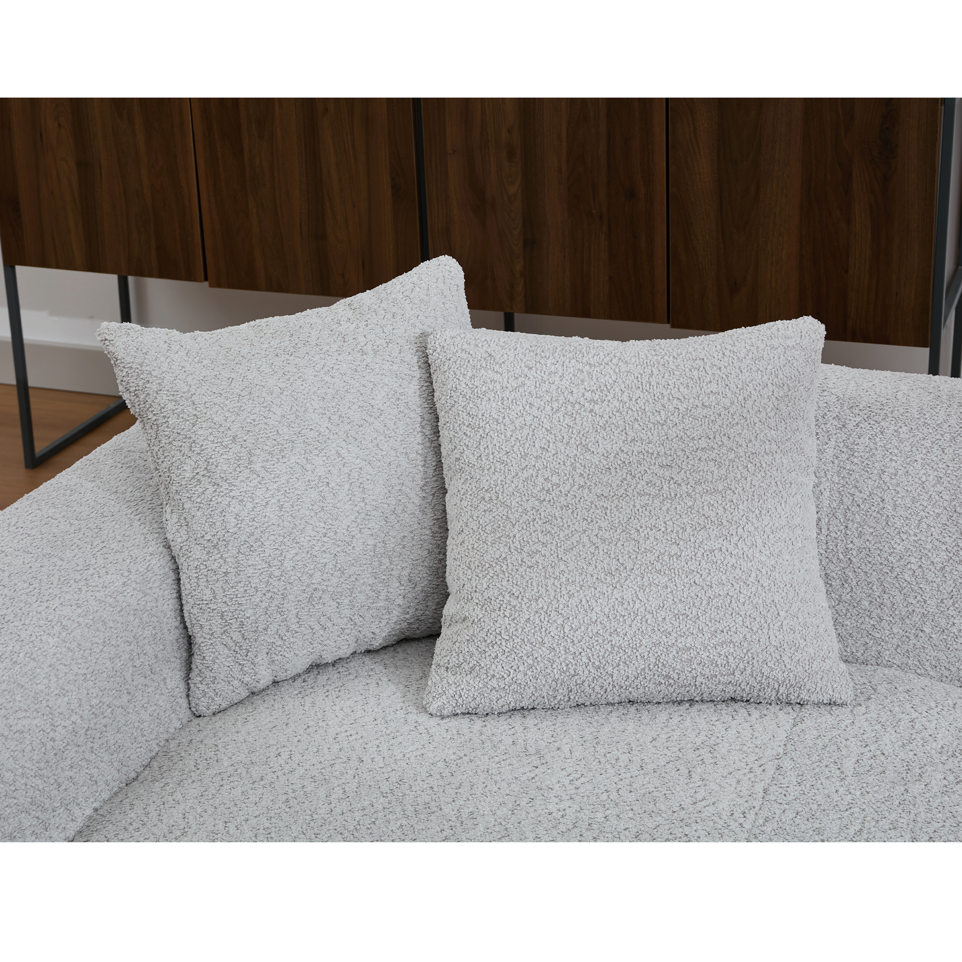 Two light gray boucle throw pillows on a matching sofa adding cozy texture