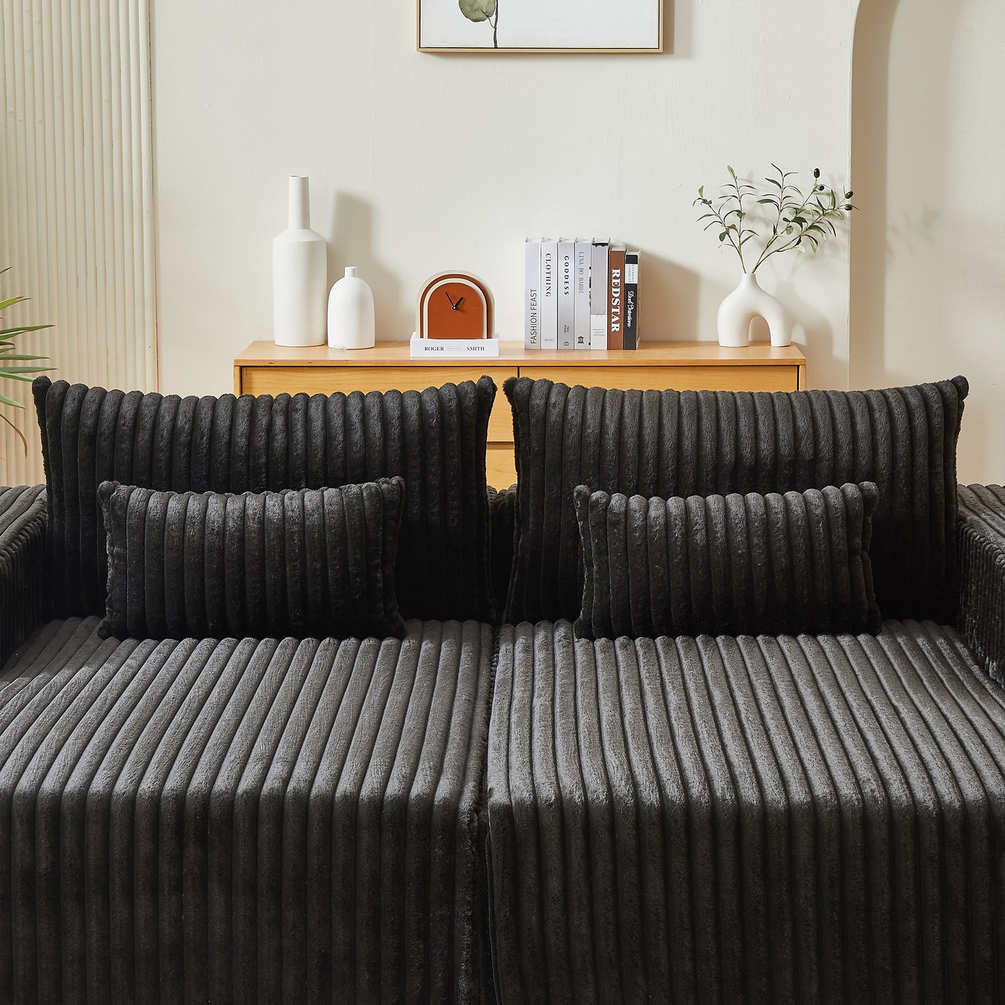 Dark gray plush corduroy sofa with matching decorative pillows for a cozy living room setup