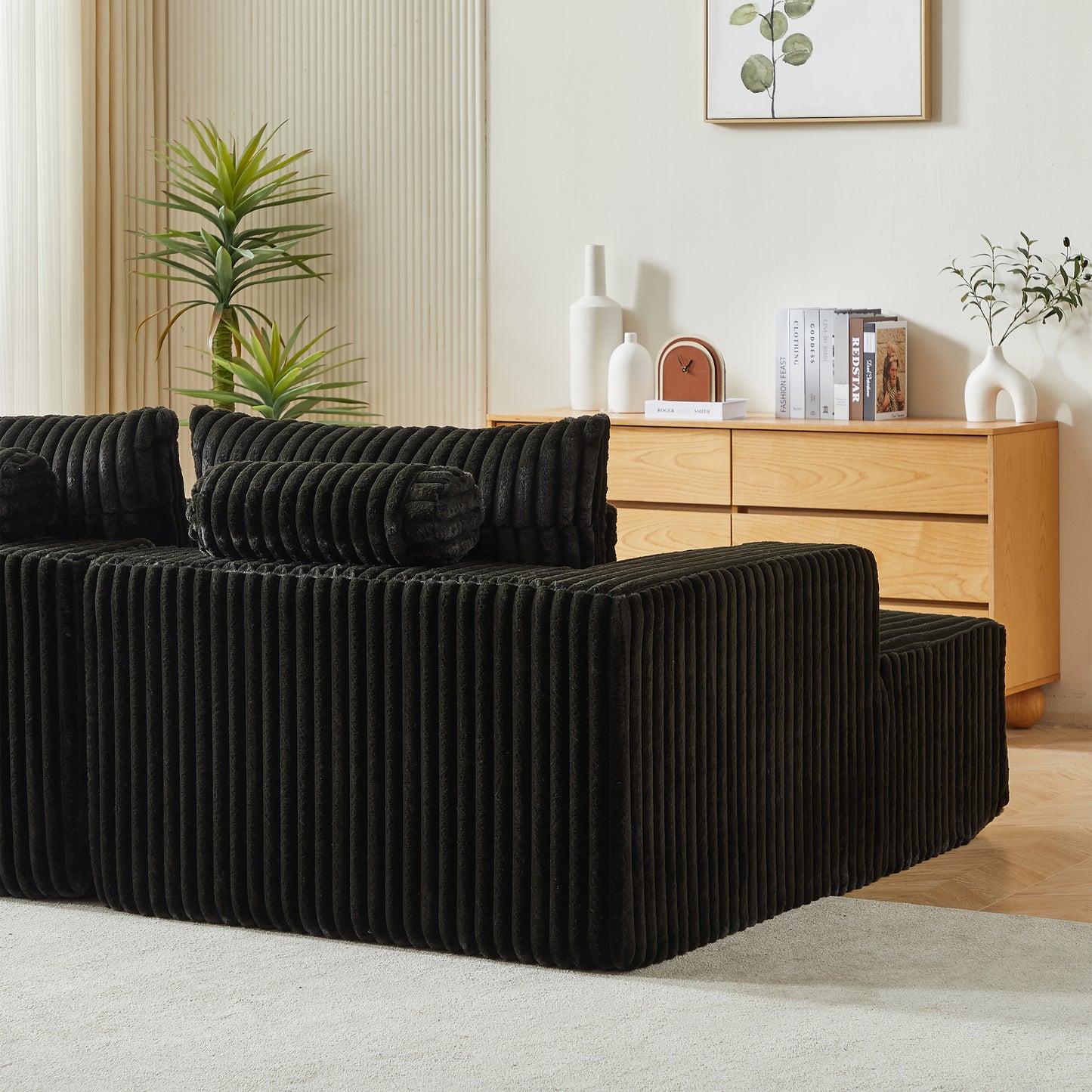 Black corduroy sofa with plush cushions and a modern minimalist design