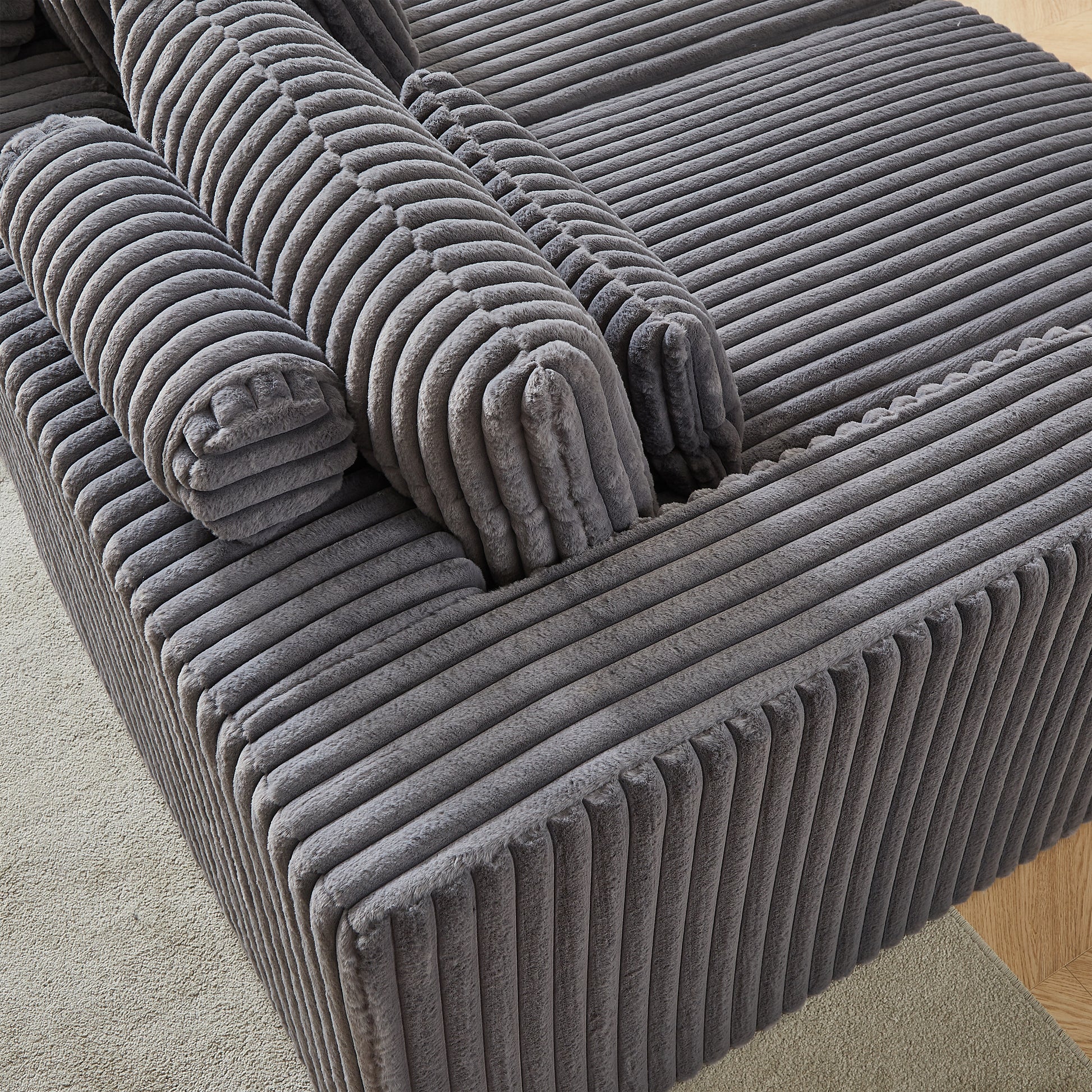 Plush grey corduroy sofa with removable bolster cushions for comfortable seating
