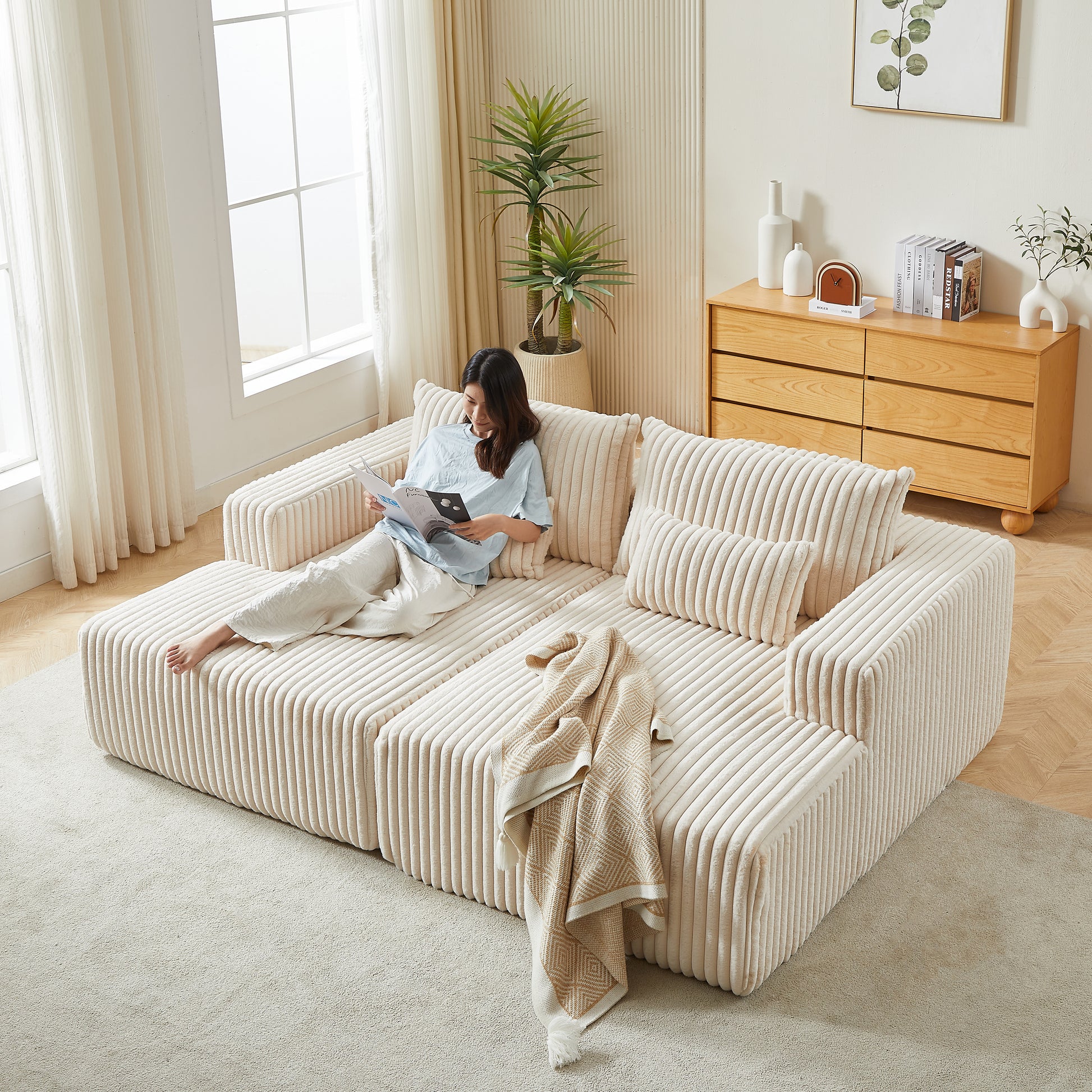 Cream corduroy modular sofa with a woman reading a magazine