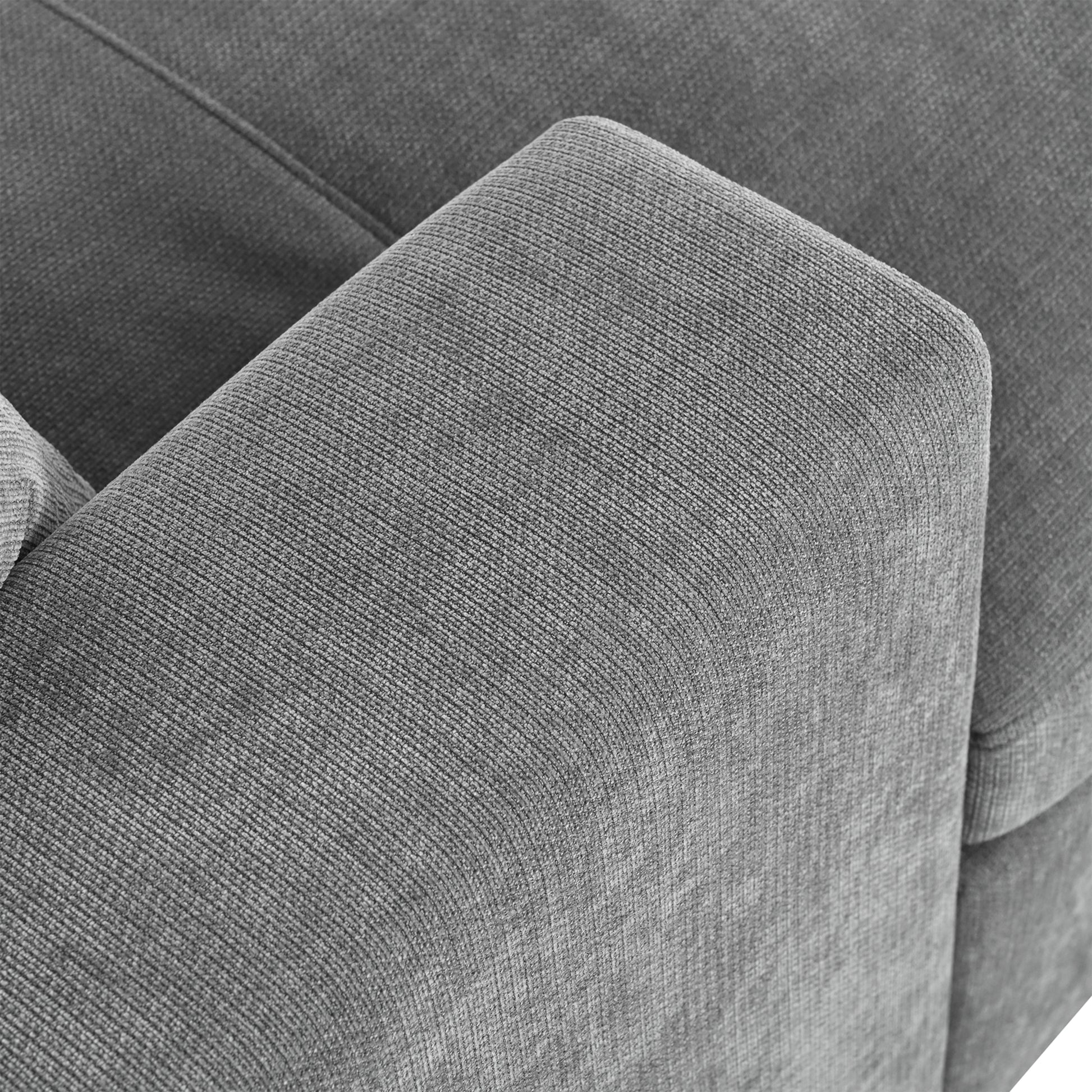 Closeup of textured gray fabric upholstery on a modern sofa armrest