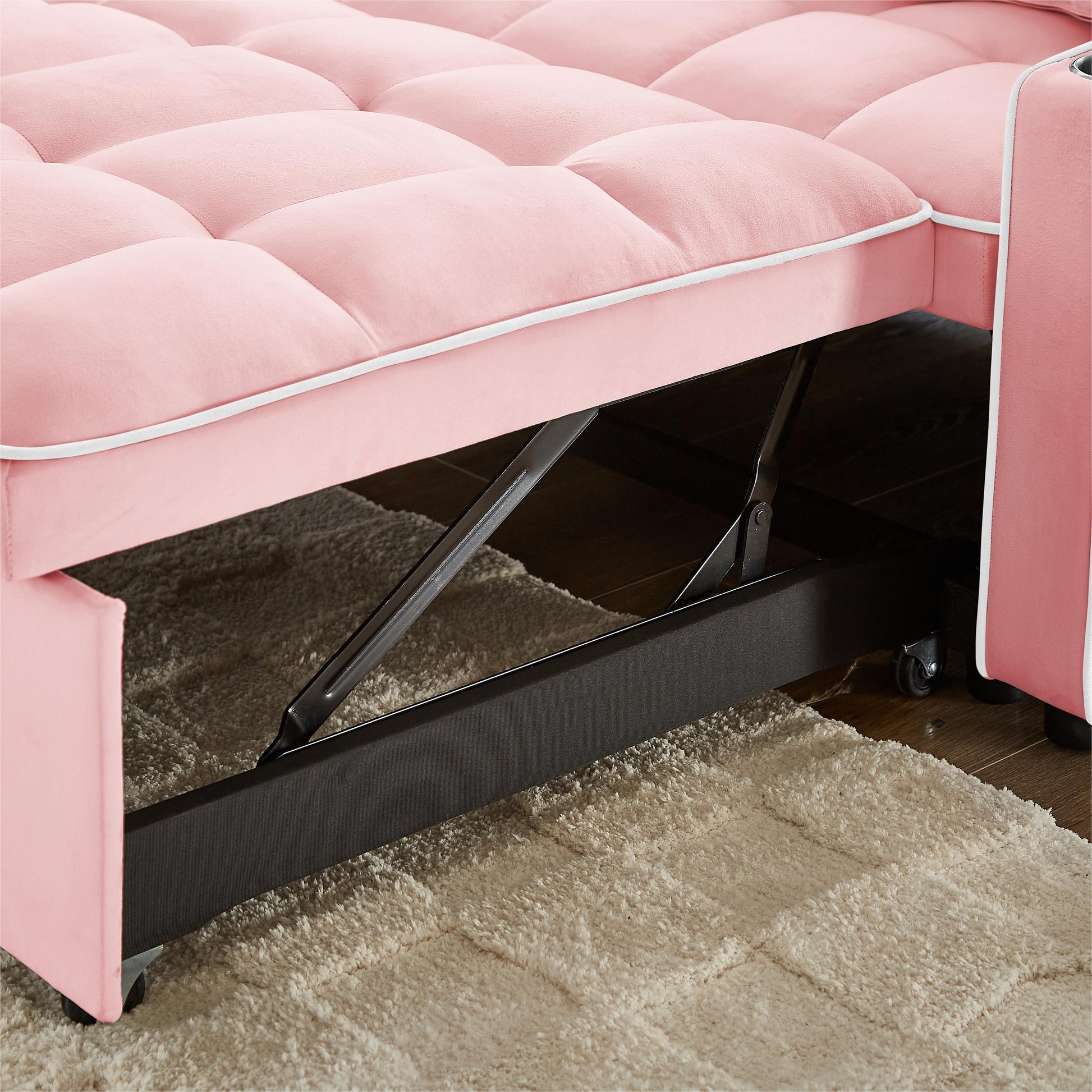 Closeup of pink velvet sofa with tufted cushions and pullout bed mechanism