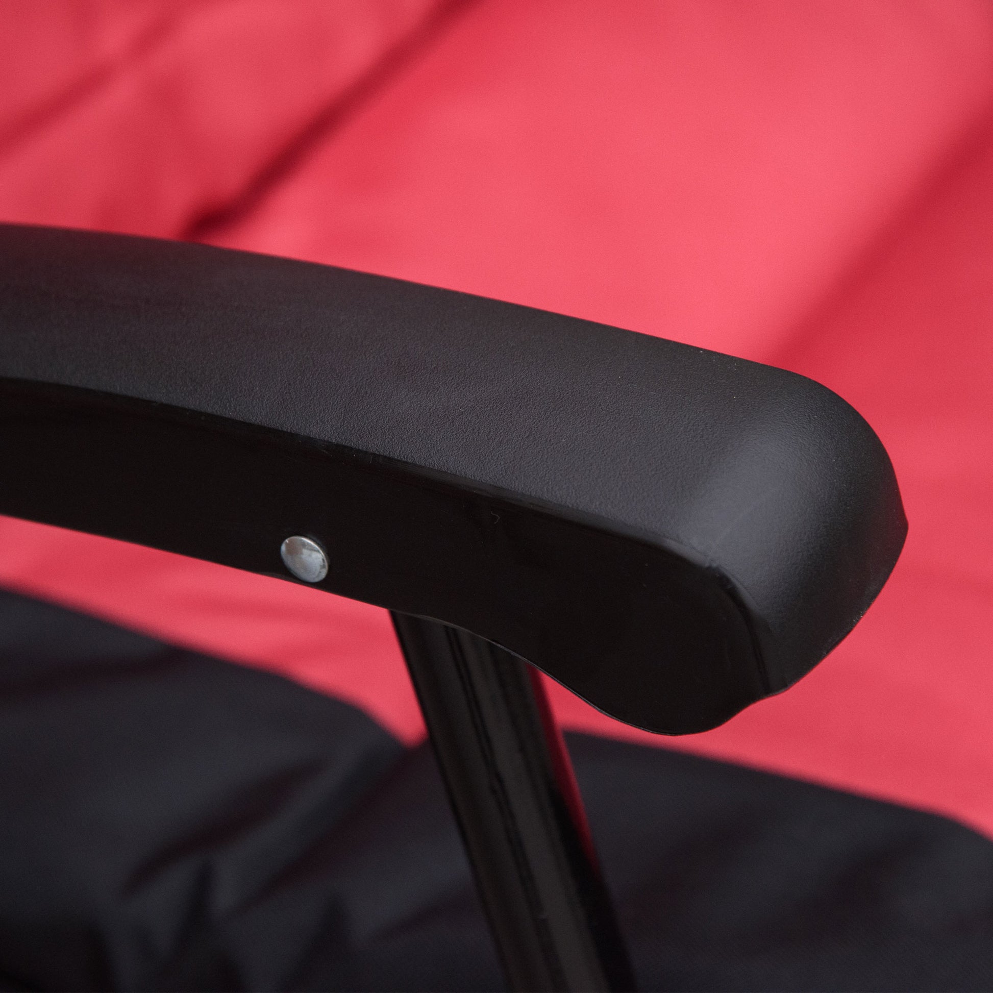 Black fabric camping chair armrest with red background detail