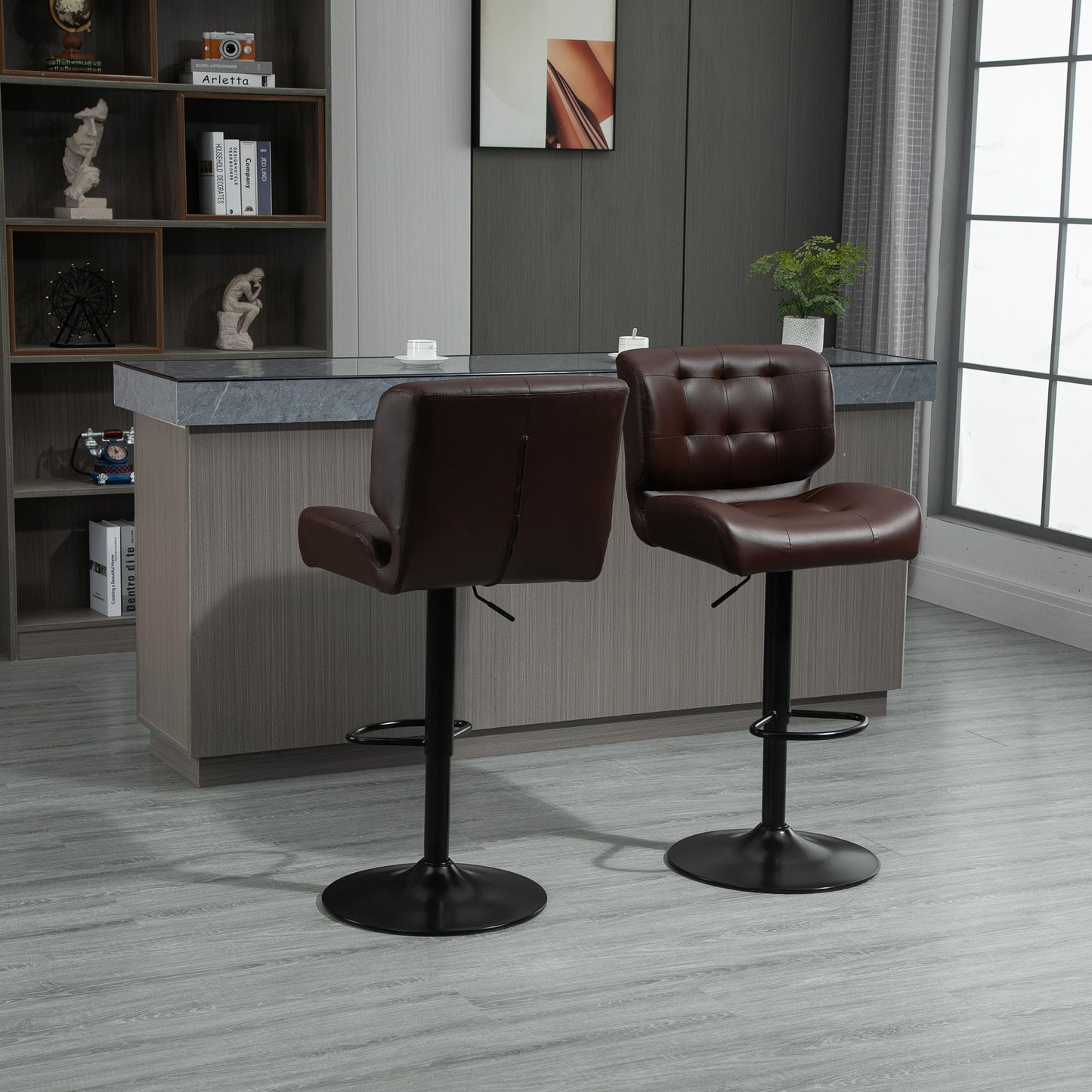 Two brown tufted leather bar stools with adjustable height and black metal bases