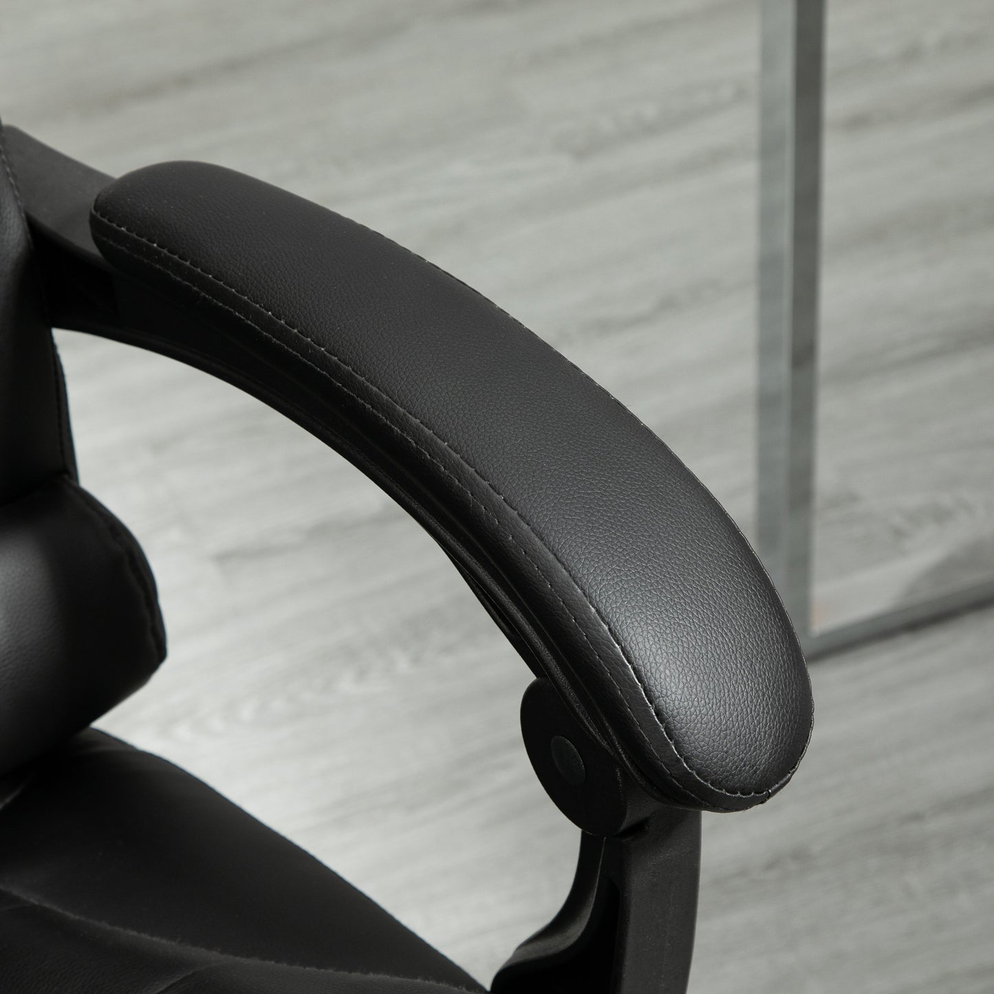 Black faux leather armrest with white stitching on an ergonomic office chair