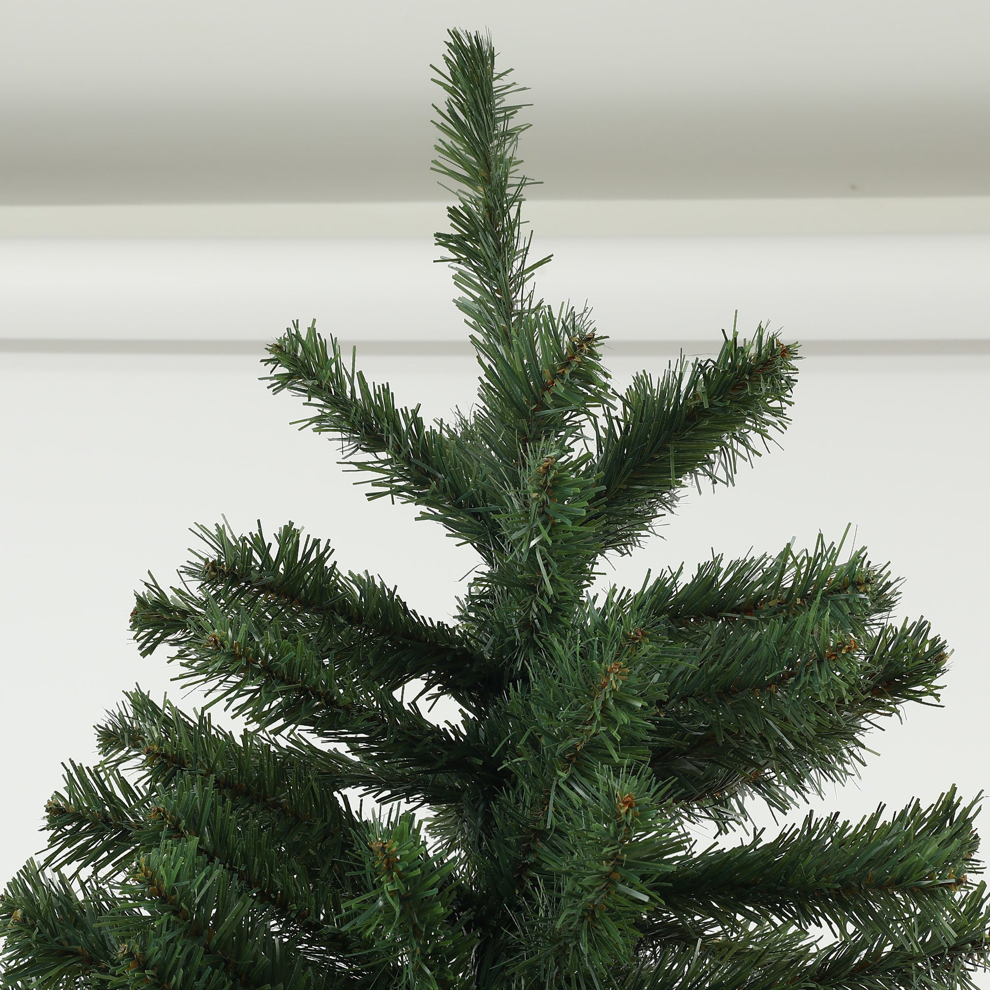 Closeup of a realistic artificial christmas tree with dense green pine needles and small brown tips
