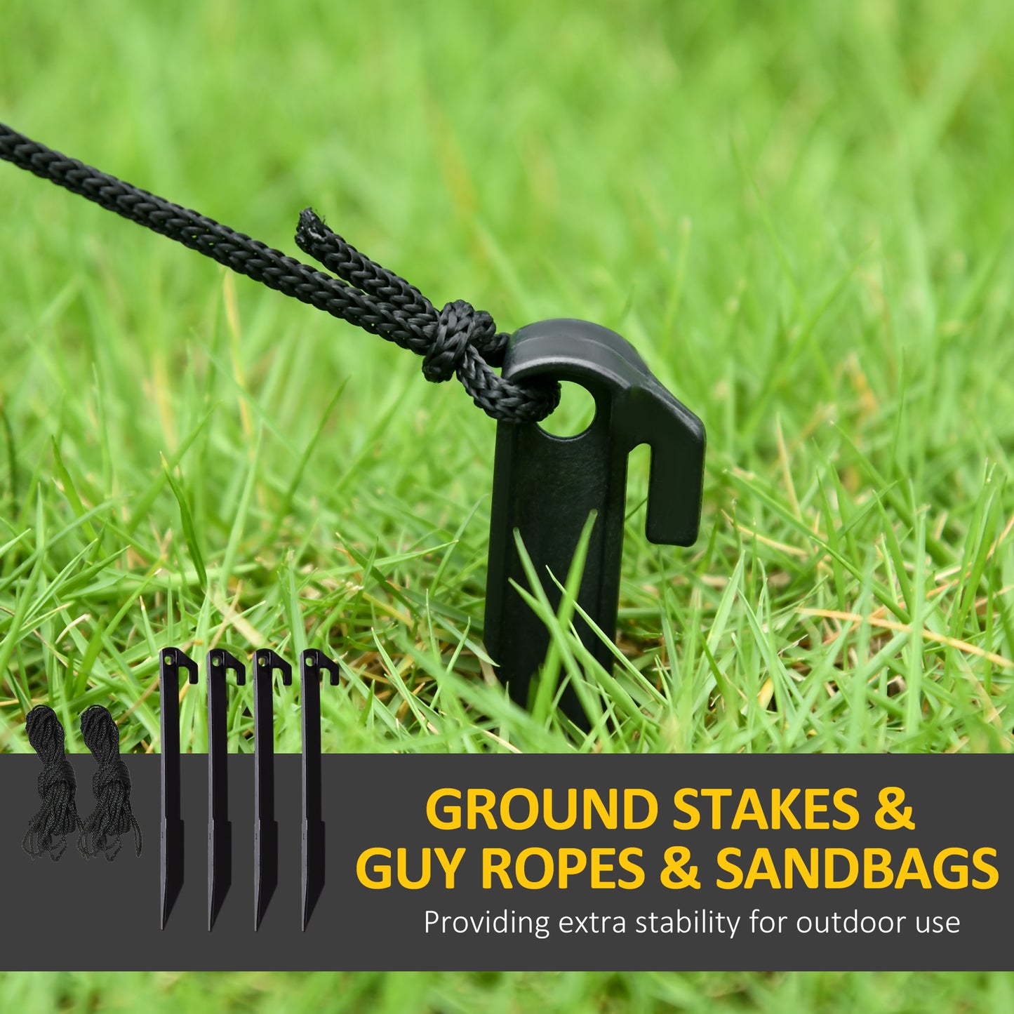 Four black tent ground stakes driven into grass with guy ropes attached