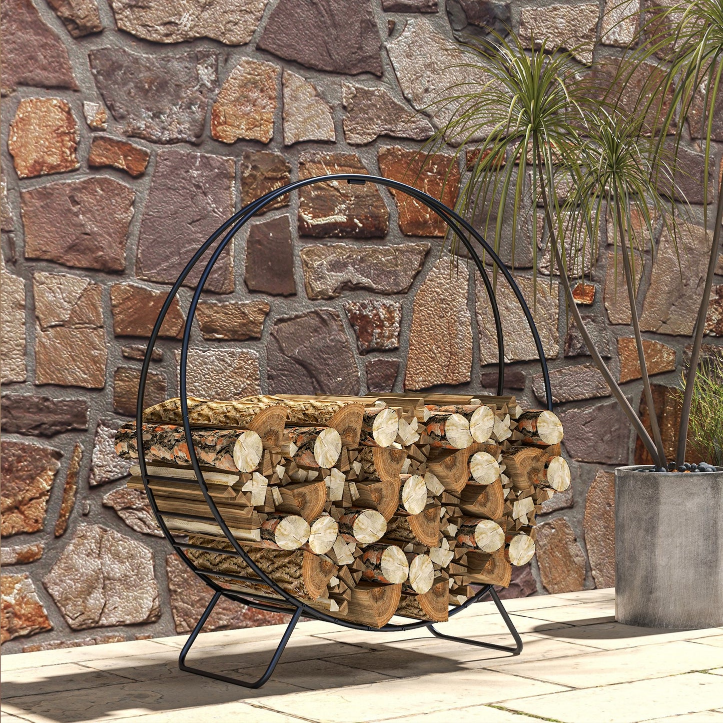 Round black metal firewood rack filled with split logs ideal for outdoor patio use