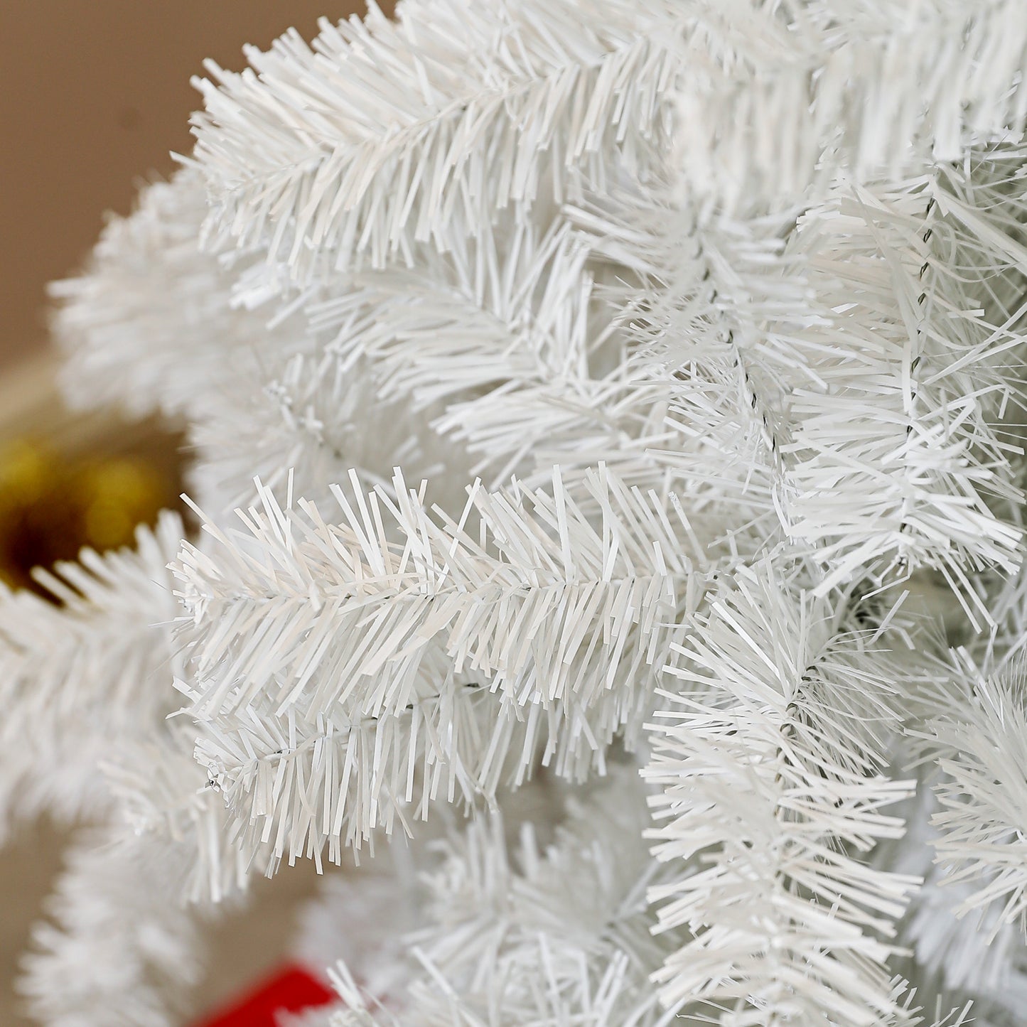 Closeup view of fluffy white artificial pine needles on a Christmas tree branch