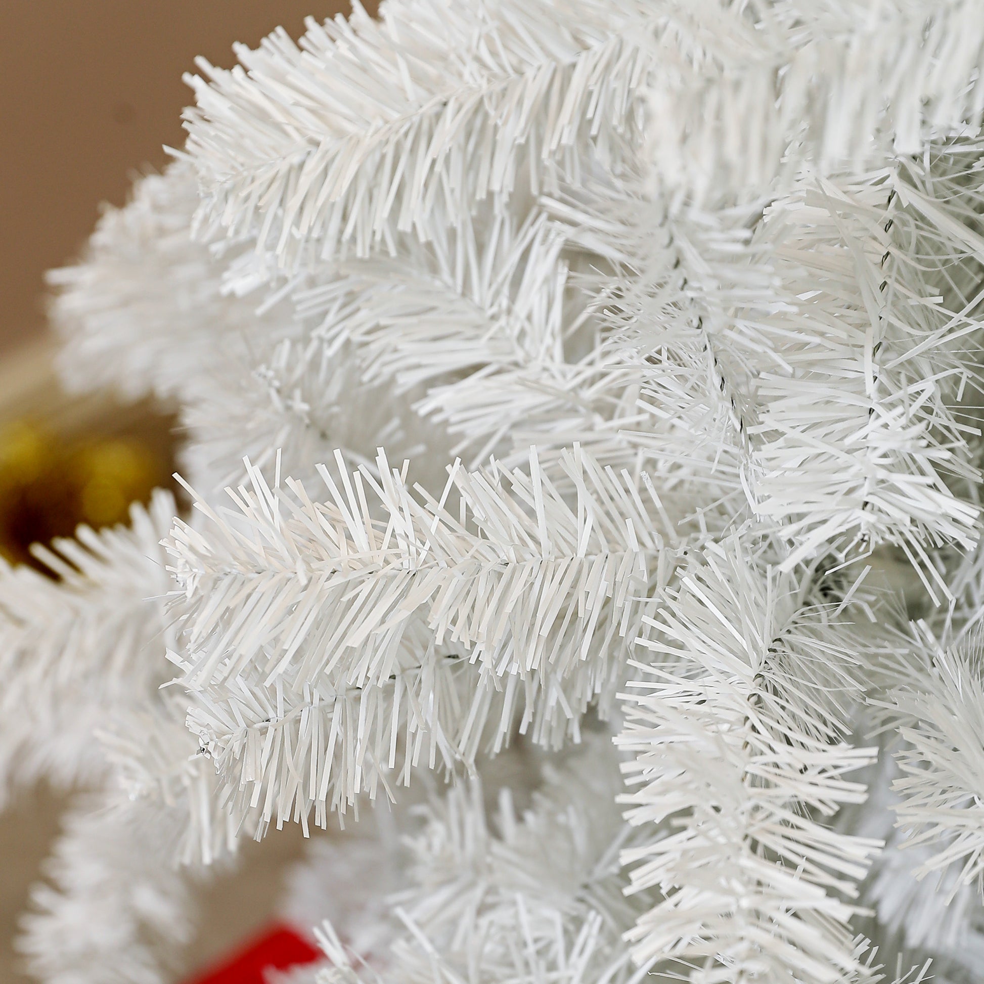 Closeup view of fluffy white artificial pine needles on a Christmas tree branch