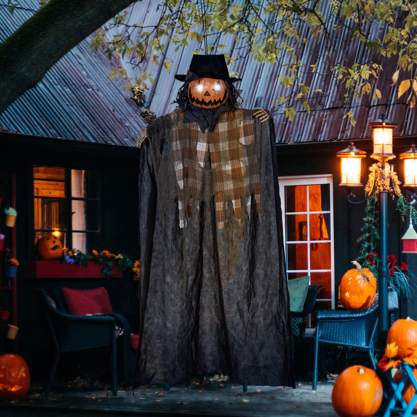 Animated jackolantern figure with glowing eyes black hat and tattered plaid shirt for Halloween decor