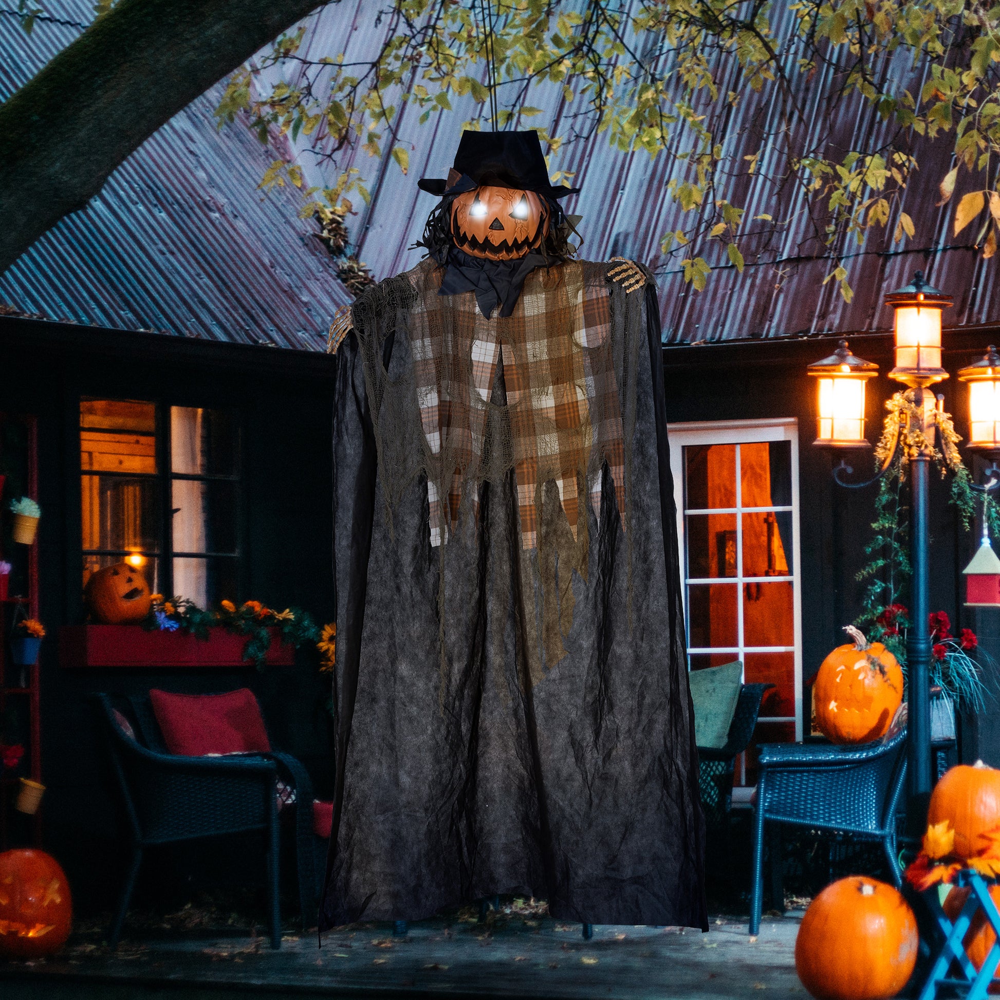 Animated jackolantern figure with glowing eyes black hat and tattered plaid shirt for Halloween decor