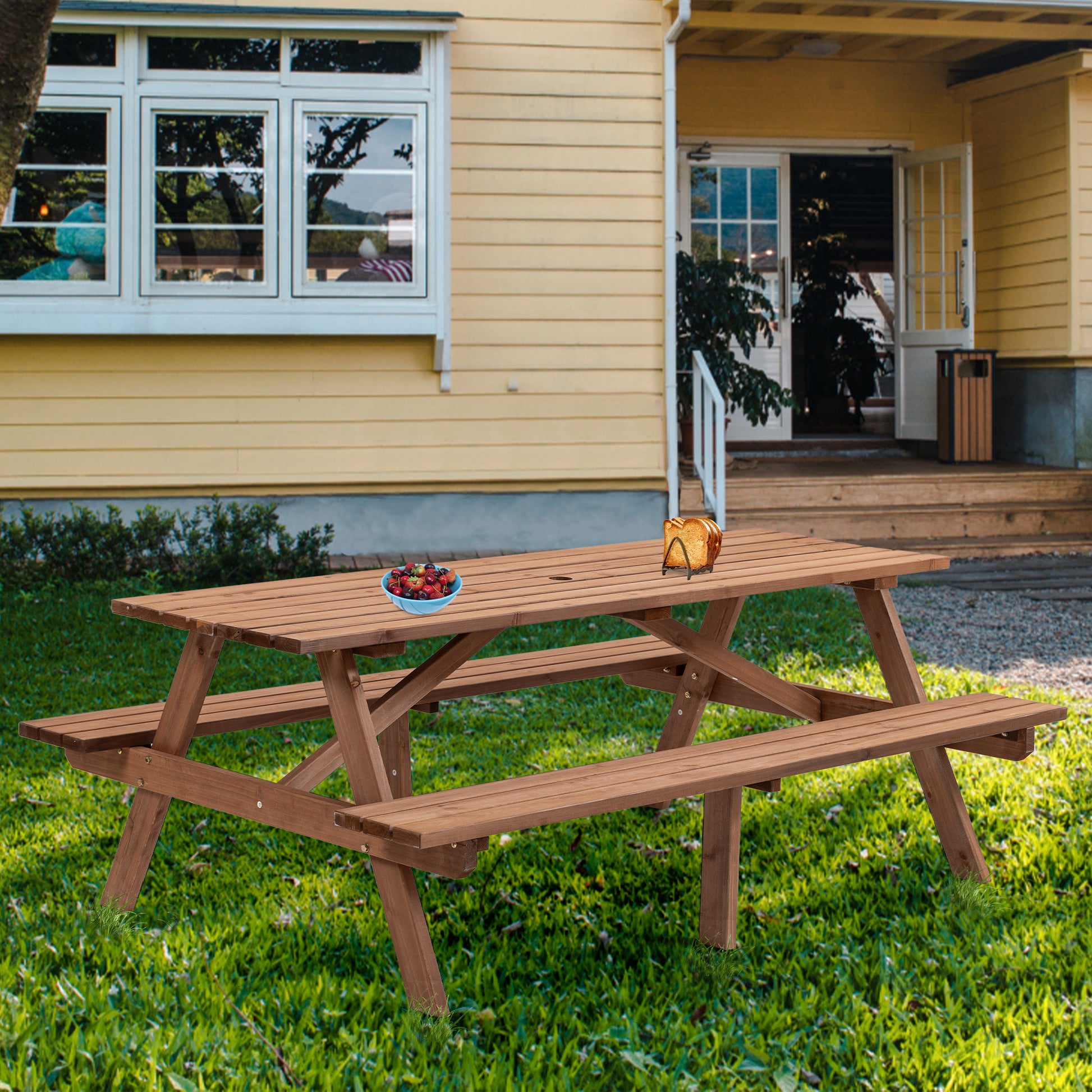 Brown wooden picnic table with attached benches set in a grassy backyard for outdoor dining