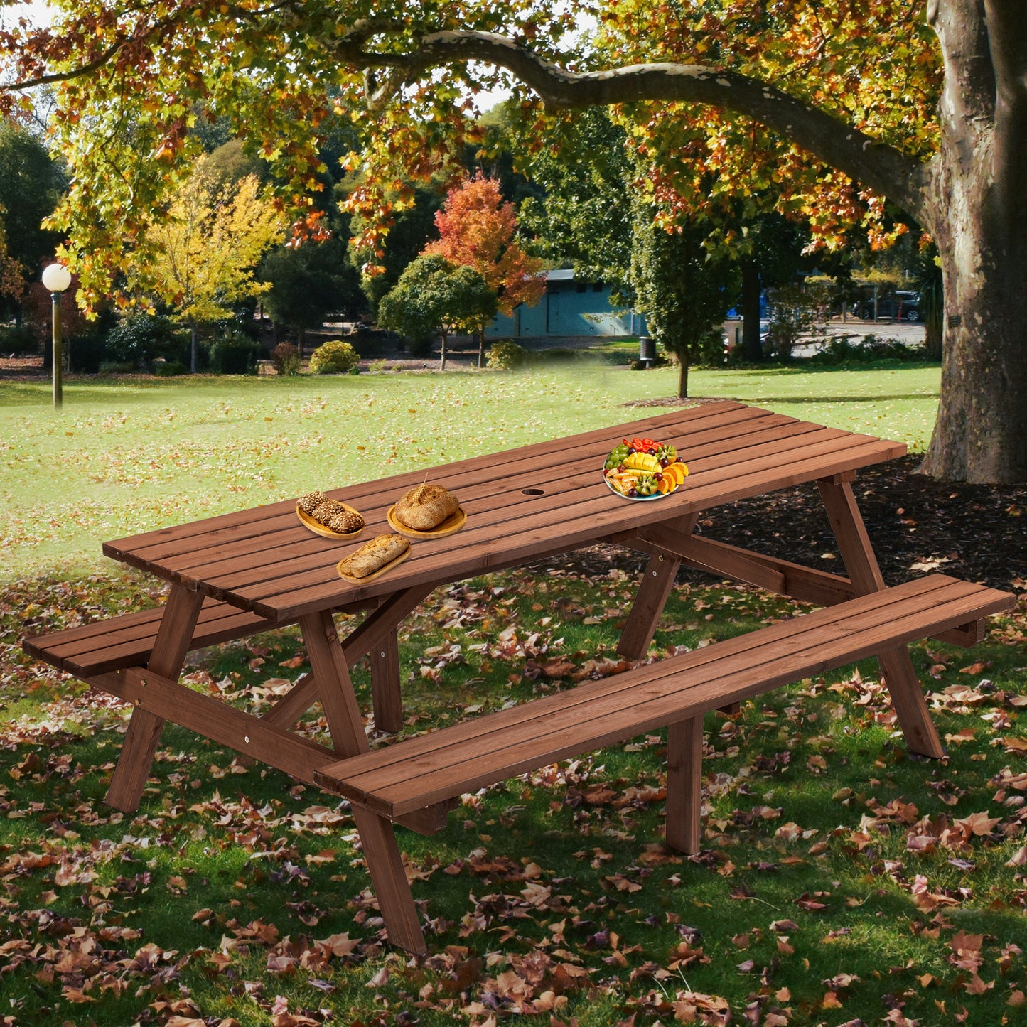 Wooden picnic table with attached benches set up in an autumn park setting