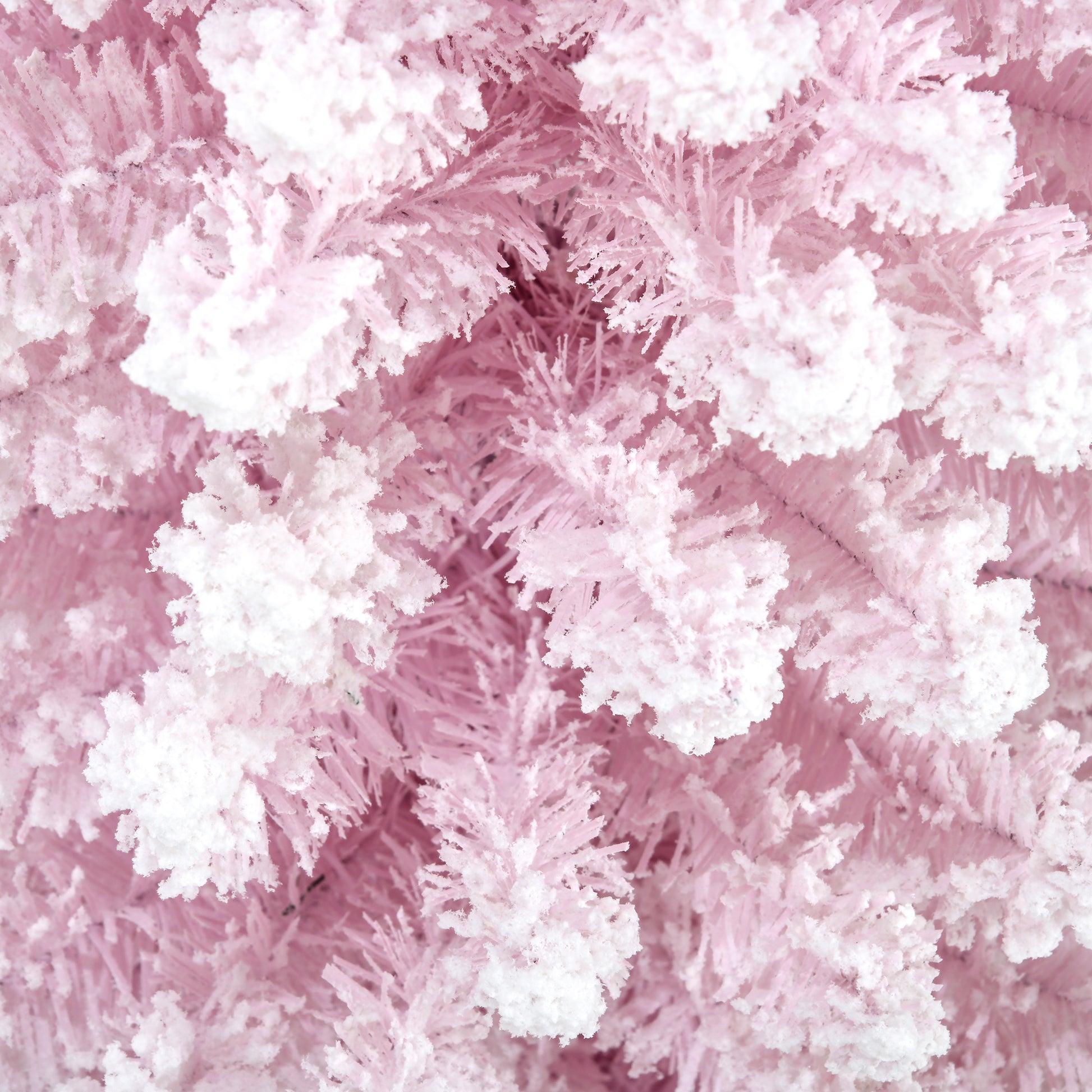 Closeup of flocked pink artificial Christmas tree branches adding a festive touch