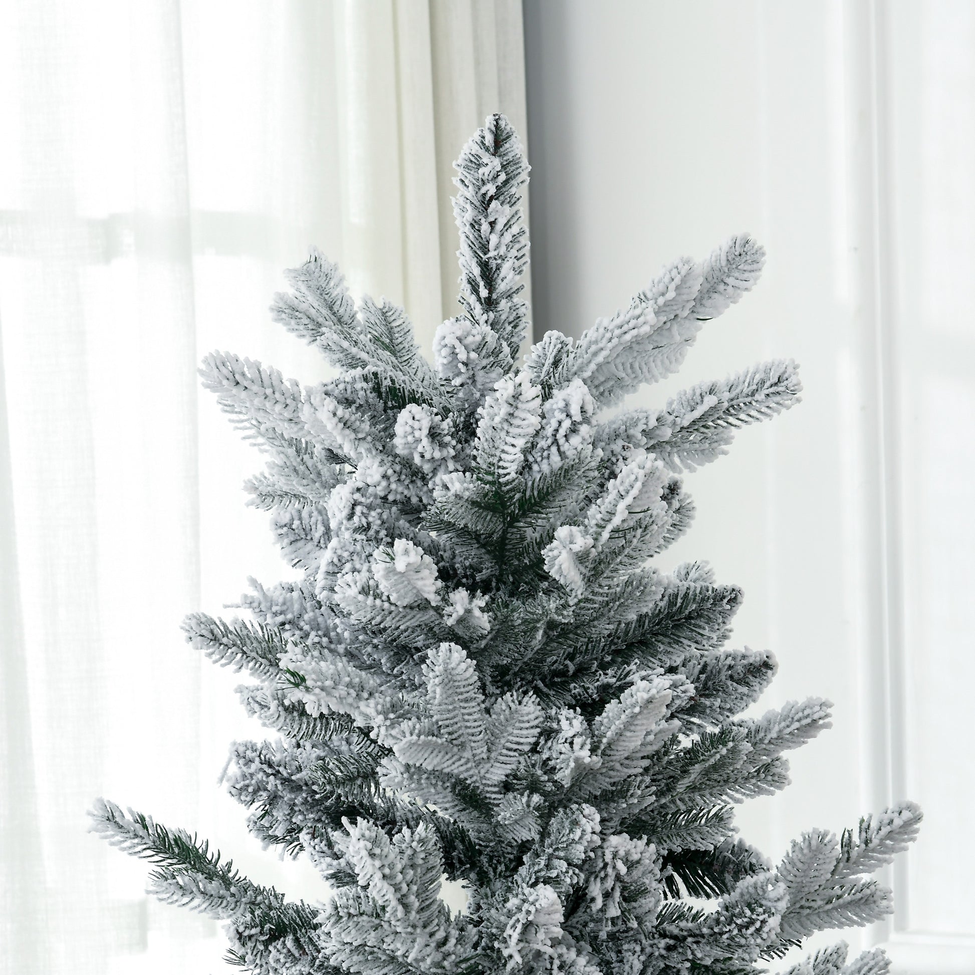 Flocked artificial Christmas tree with realistic green branches covered in white snow perfect for holiday decor