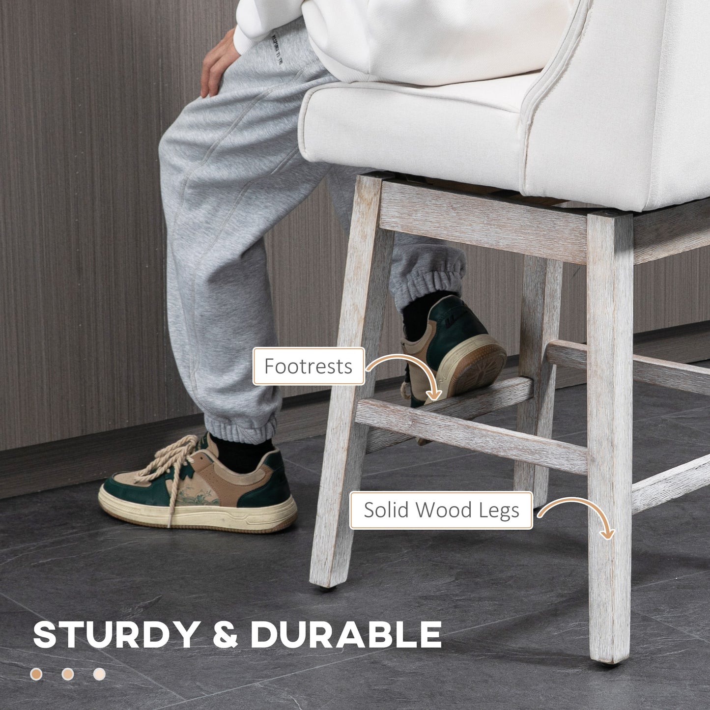 Close up of a white upholstered bar stool with footrests and solid wood legs