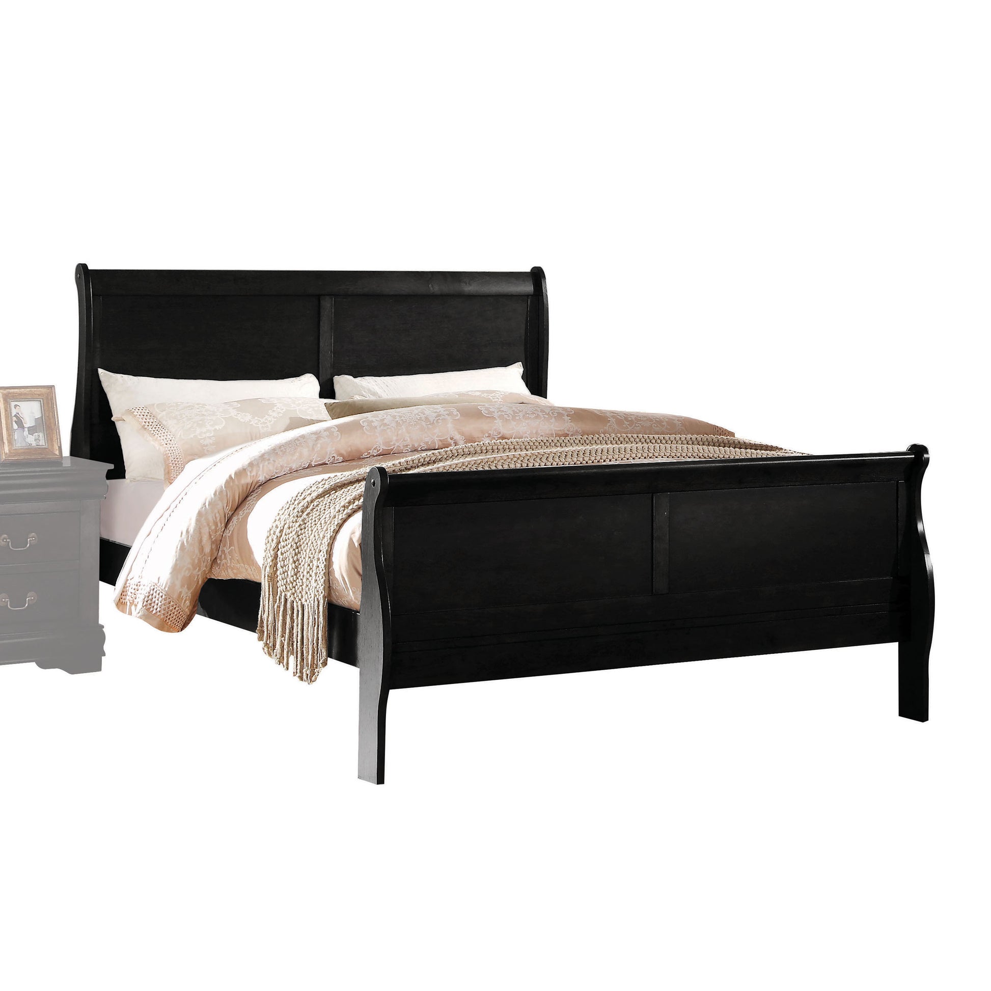 Black wooden sleigh bed with ornate pillows and a knit throw