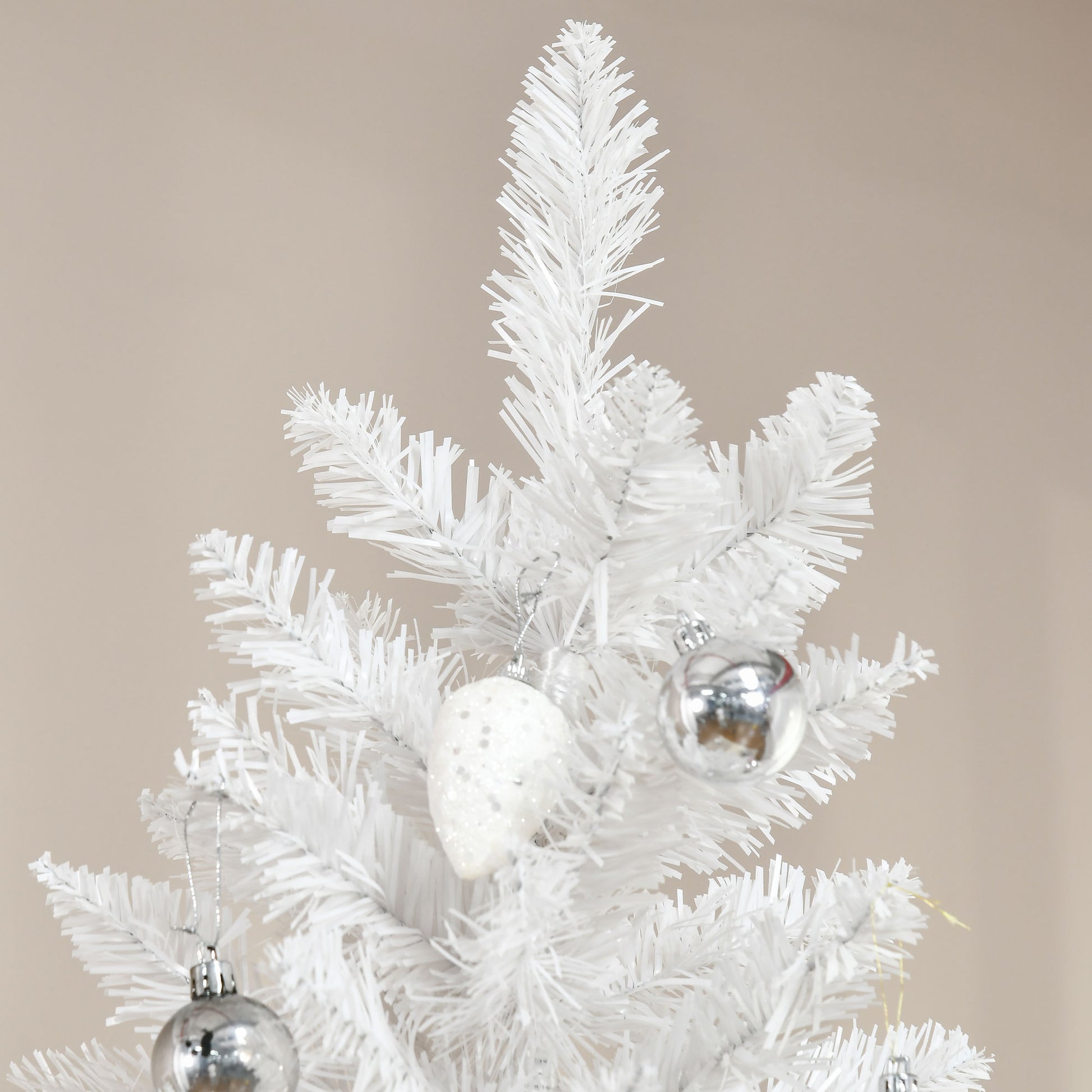 Closeup of a white artificial Christmas tree with silver and glitter ornaments