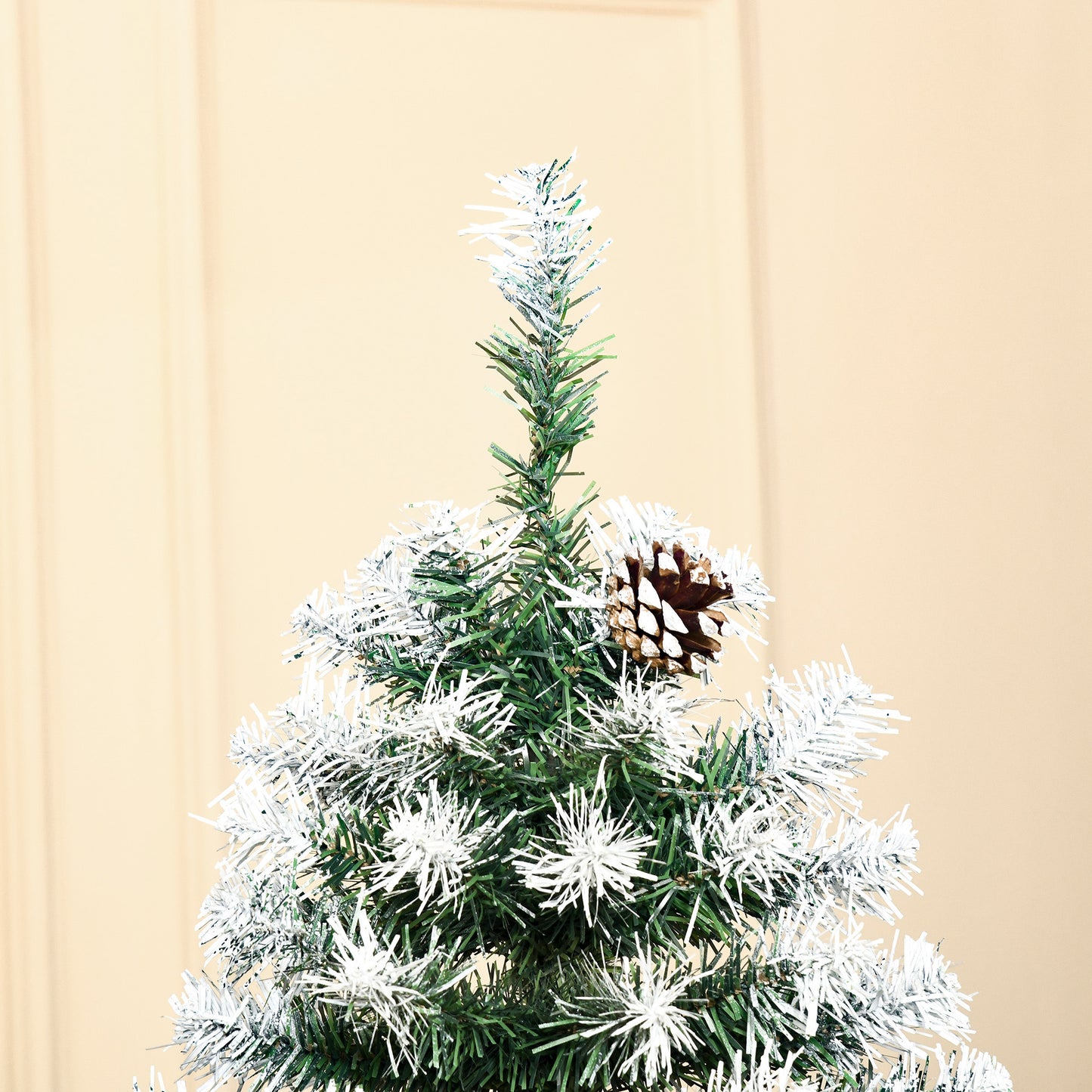 Frosted artificial Christmas tree with a realistic pine cone ornament