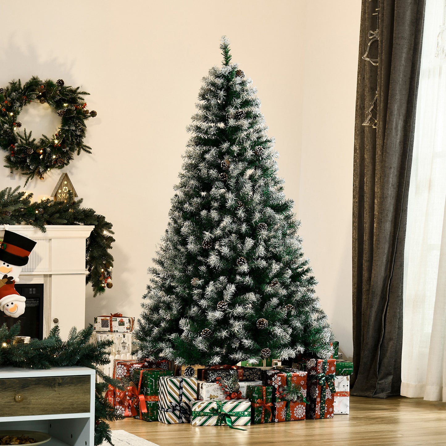 Frosted artificial Christmas tree with pinecones and festive gifts