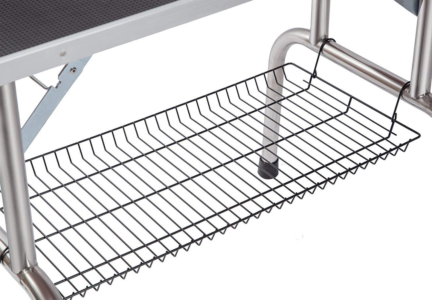 Black wire storage basket hanging from stainless steel grooming table leg