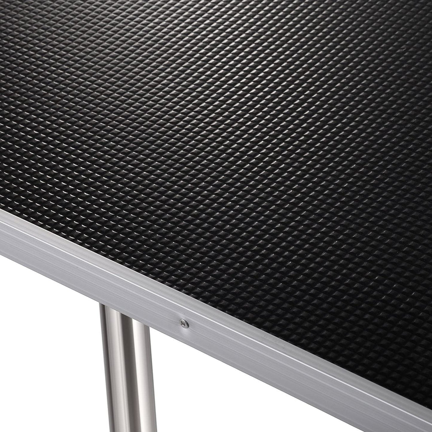 Black textured nonslip surface on a grooming table with a silver aluminum frame