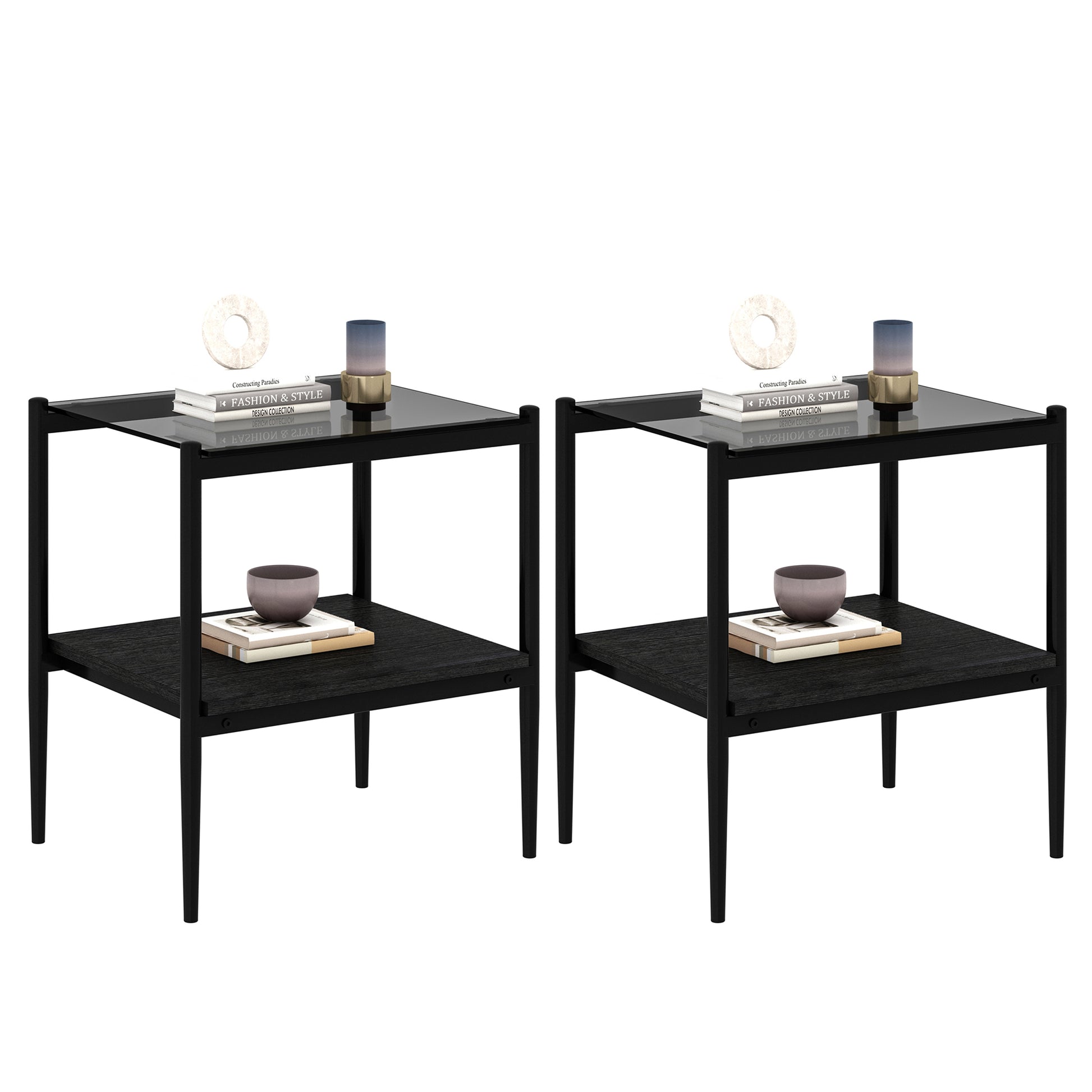 Two modern black end tables with glass tops and open lower shelves styled with books and decor