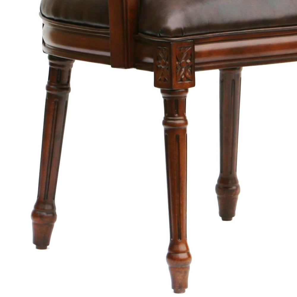 Ornate carved wooden legs on a classic dark brown leather armchair