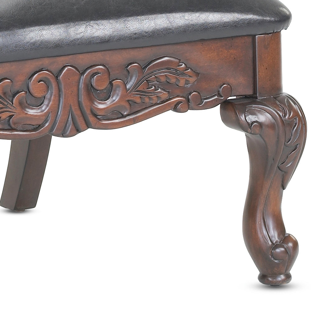 Dark brown mahogany wood armchair with carved details and leather seat