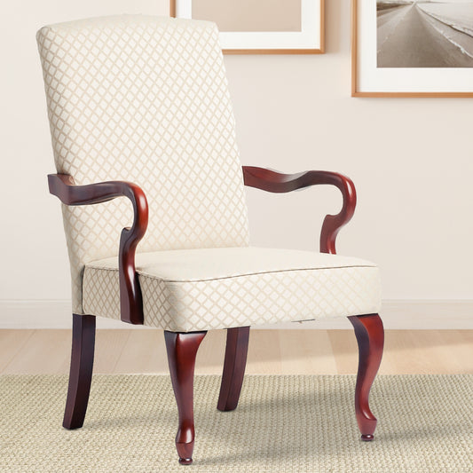 Ornate upholstered armchair in cream with diamond pattern and dark wood legs