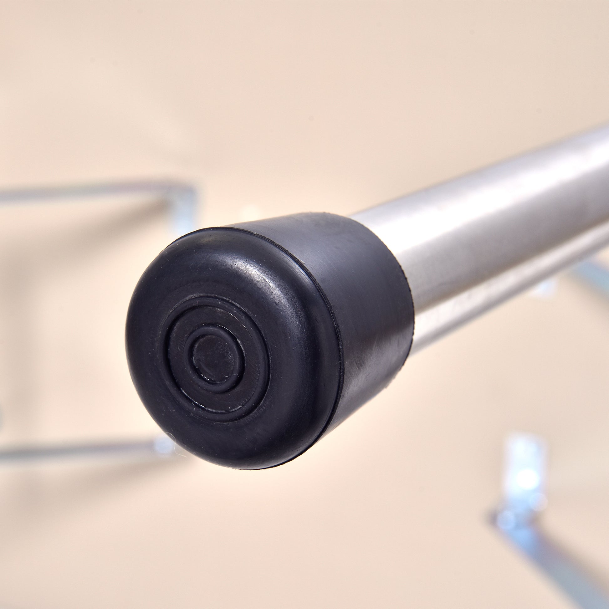 Black rubber foot cap with concentric rings on a brushed metal pole