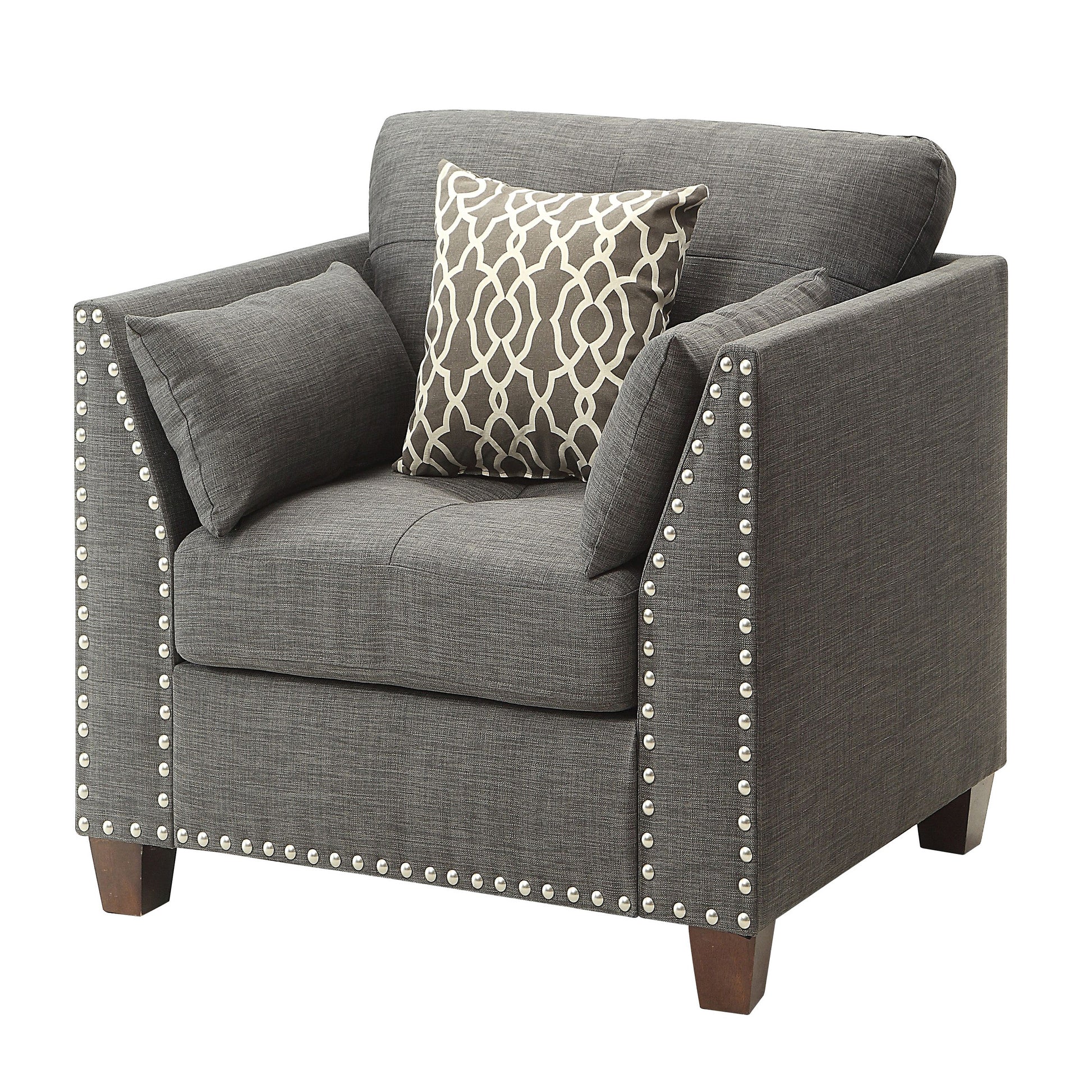 Dark gray upholstered accent chair with nailhead trim and patterned throw pillow