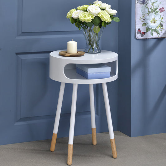 Round white side table with tapered wooden legs and open shelf storage