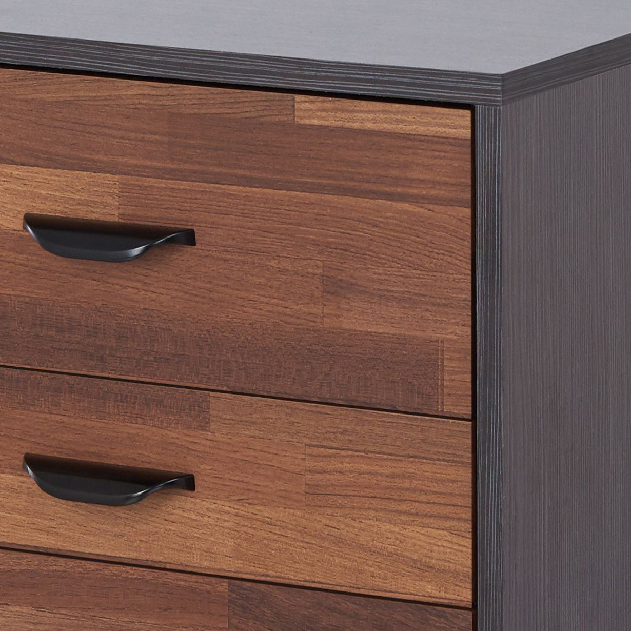 Drawer fronts of a modern chest of drawers with faux wood grain and black metal handles