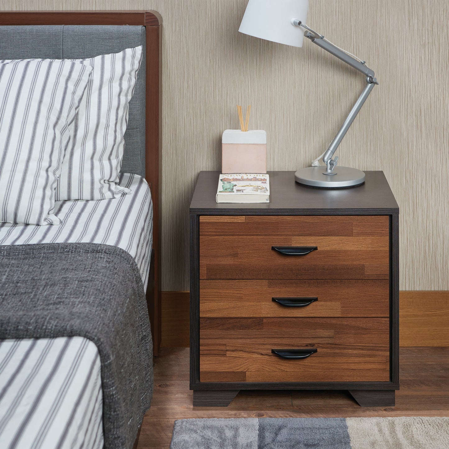 Threedrawer wood nightstand with dark wood finish and black handles