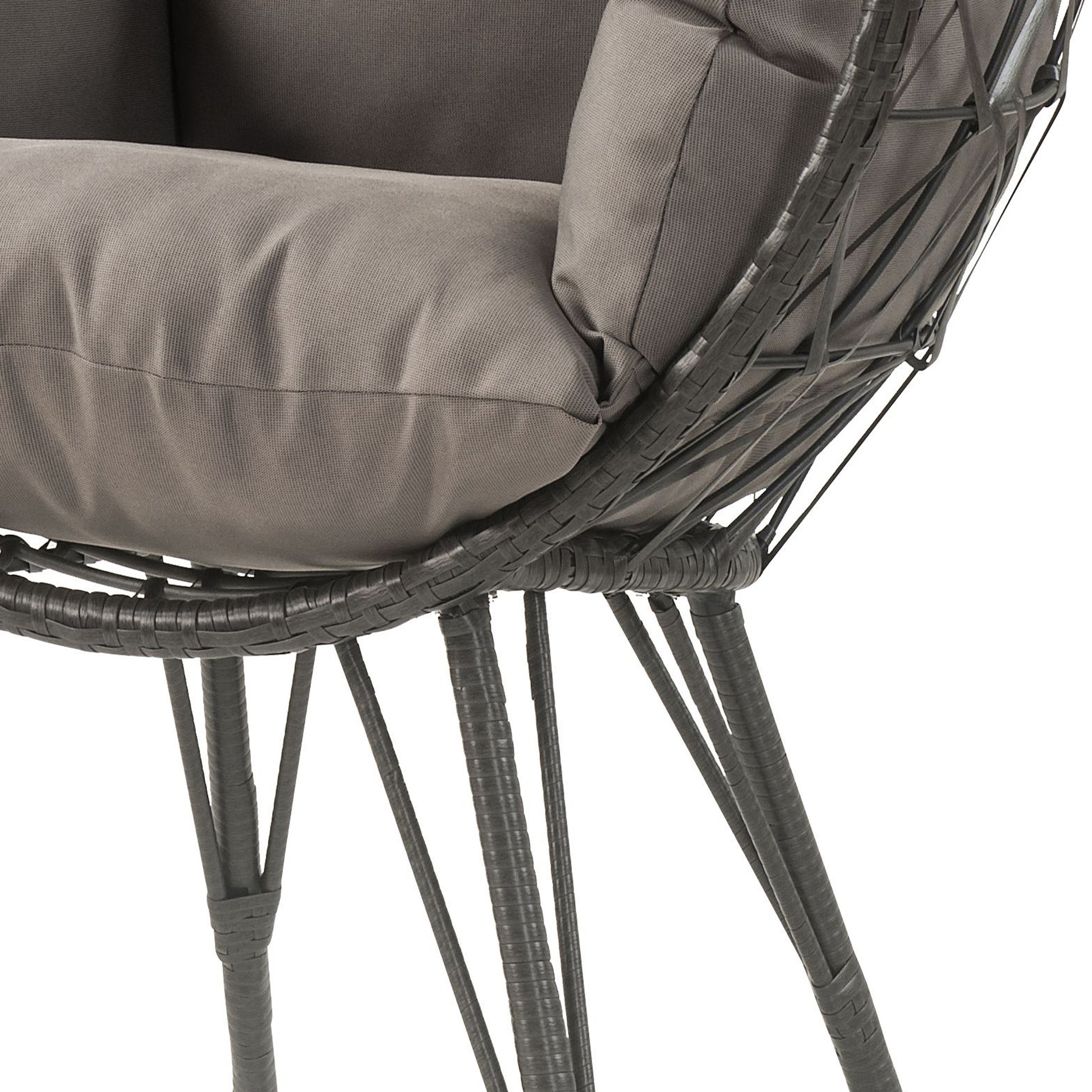 Closeup of a gray woven wicker chair with plush seat cushions and dark metal legs