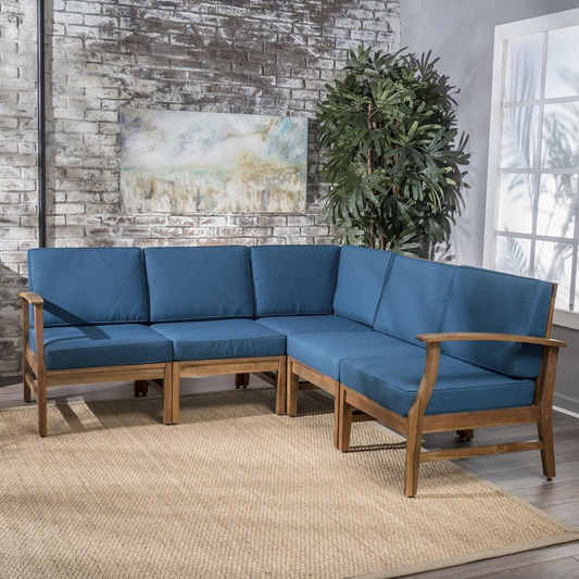 Blue upholstered modular sectional sofa with wooden frame on tan rug