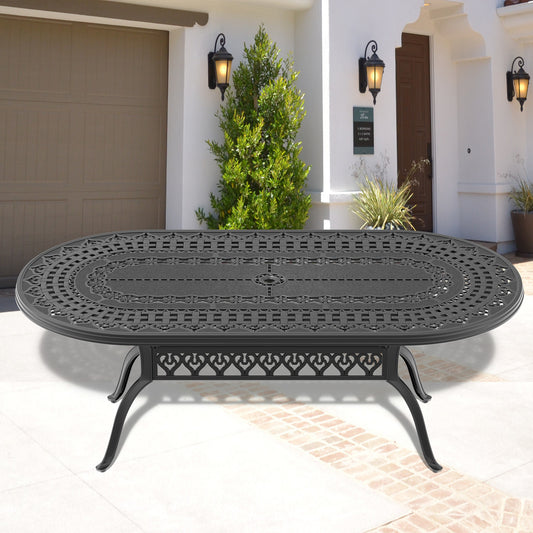 Ornate black cast aluminum oval patio dining table with intricate scrollwork and floral details