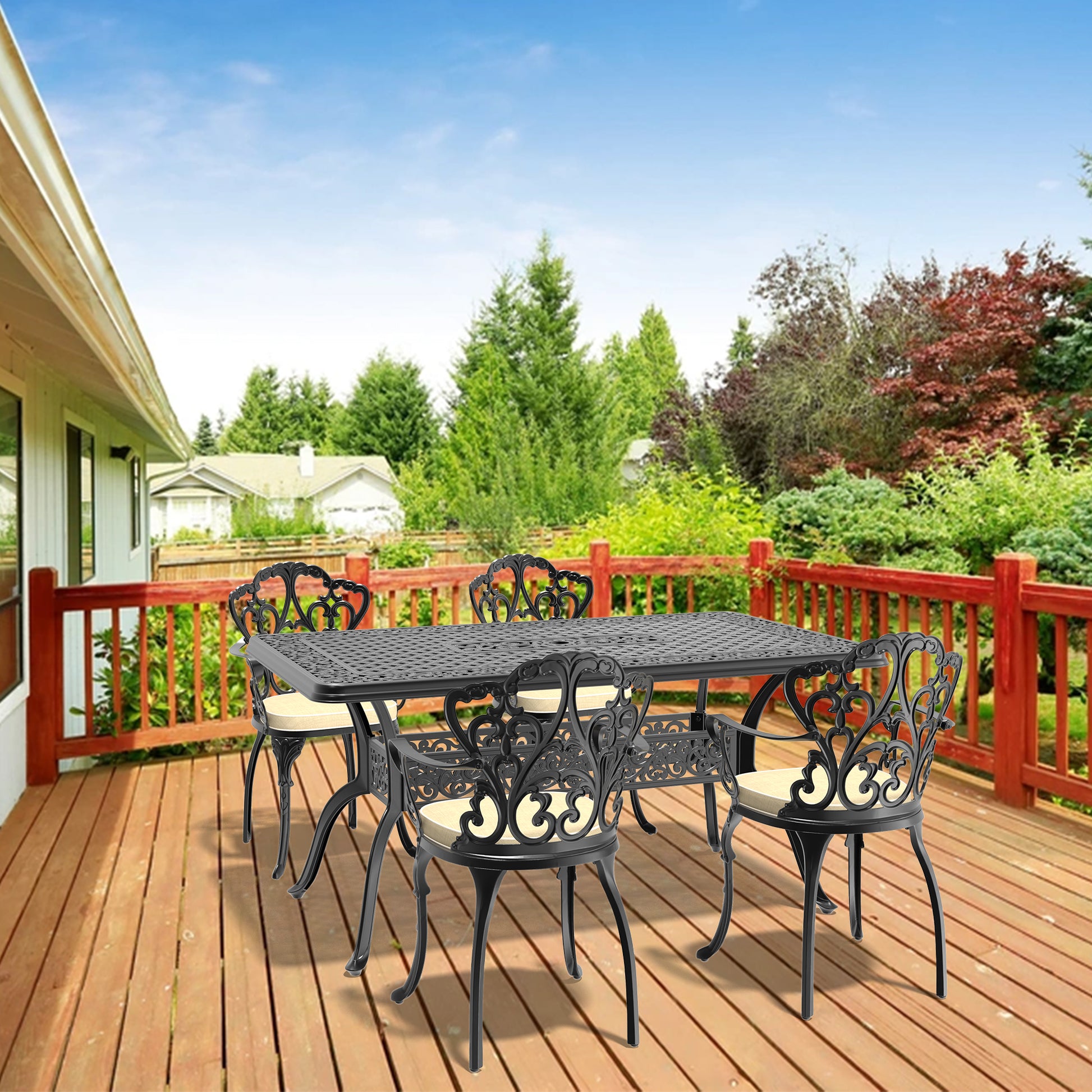 Black ornate cast iron patio dining set with cream cushions on wooden deck
