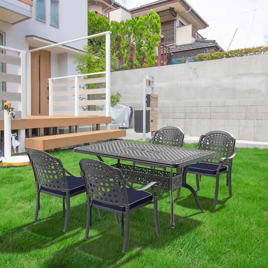 Dark grey cast aluminum patio dining set with intricate scrollwork and navy cushions