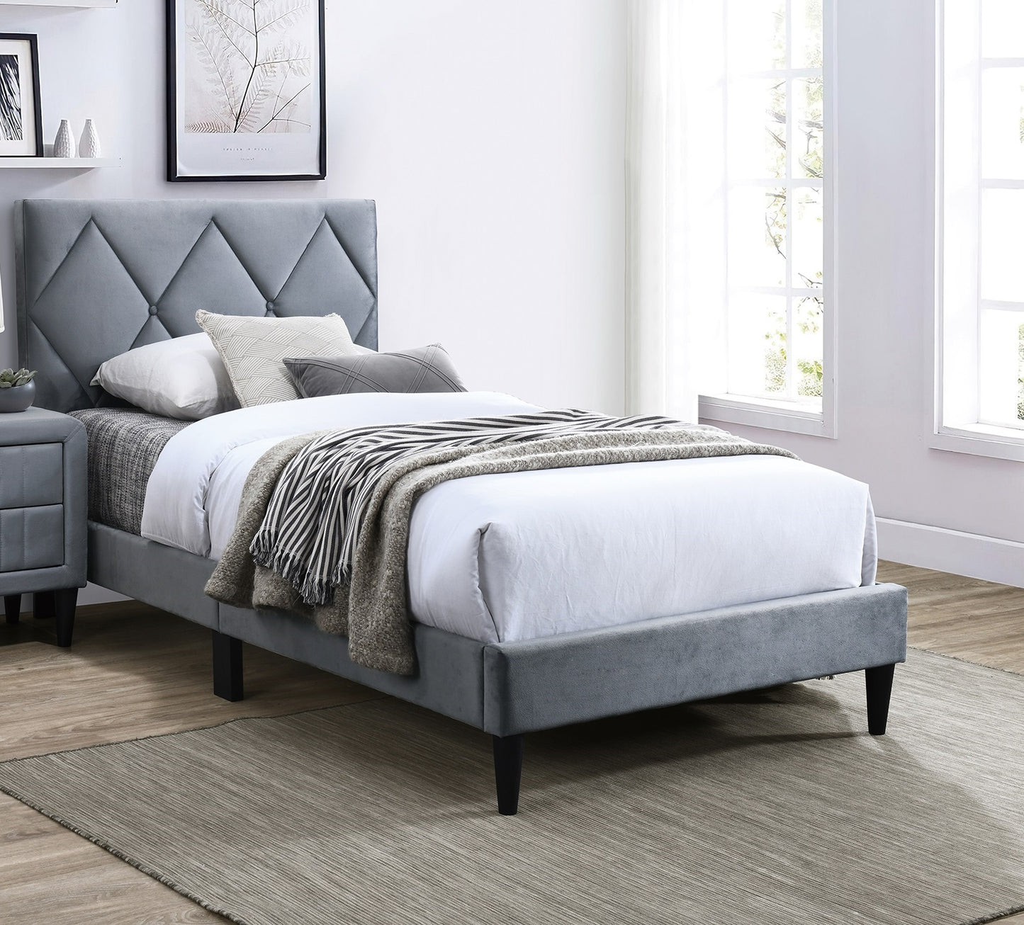 Grey velvet upholstered bed with diamond tufted headboard and wooden legs