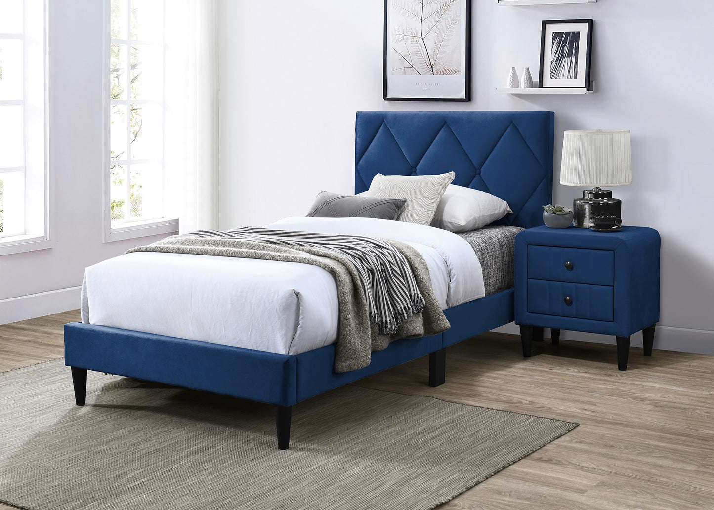 Blue velvet diamond tufted bed frame with white bedding and striped throw